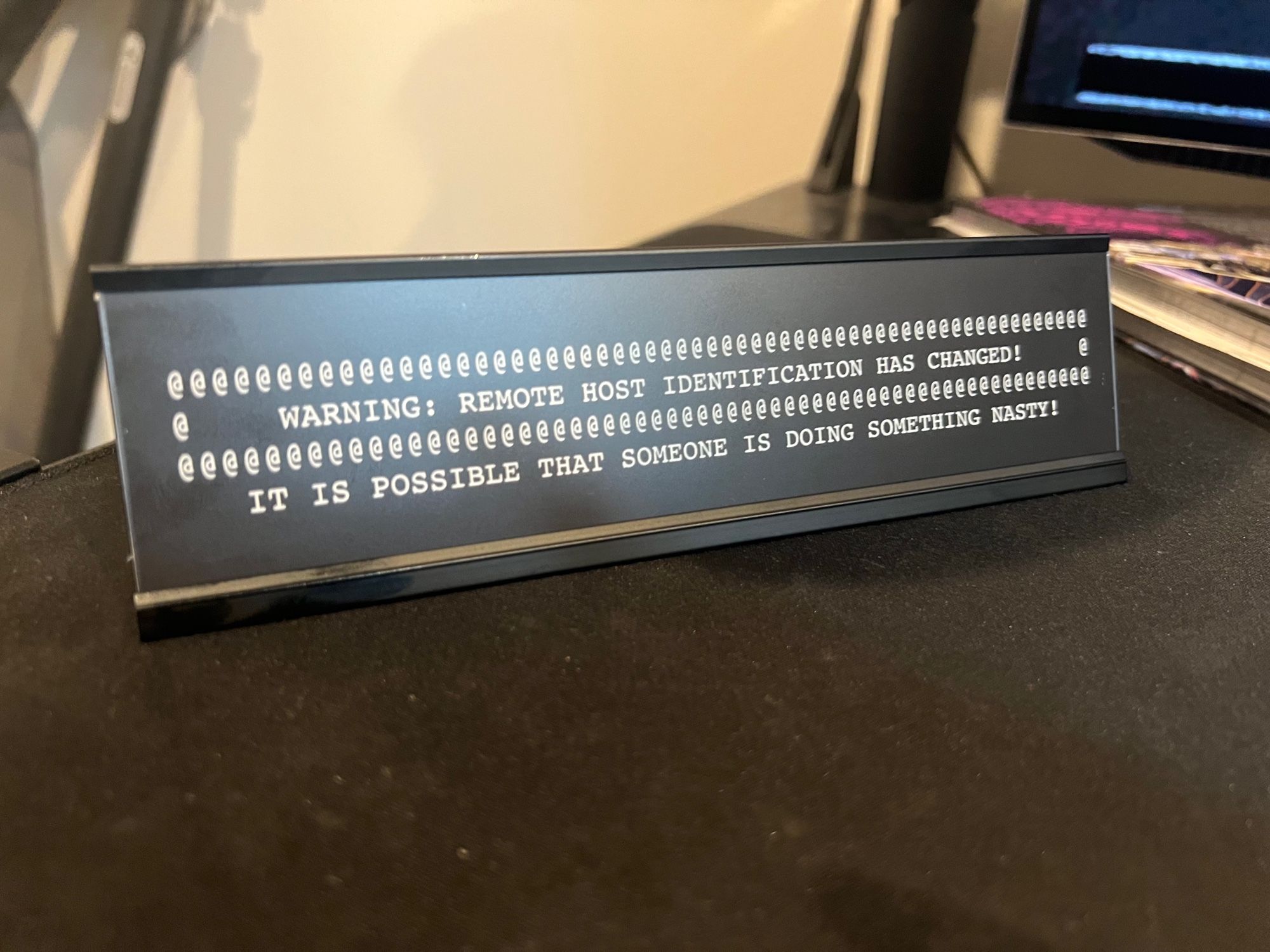 A desk nameplate that displays a warning message from OpenSSH:
WARNING: REMOTE HOST IDENTIFICATION HAS CHANGED!
IT IS POSSIBLE THAT SOMEONE IS DOING SOMETHING NASTY!