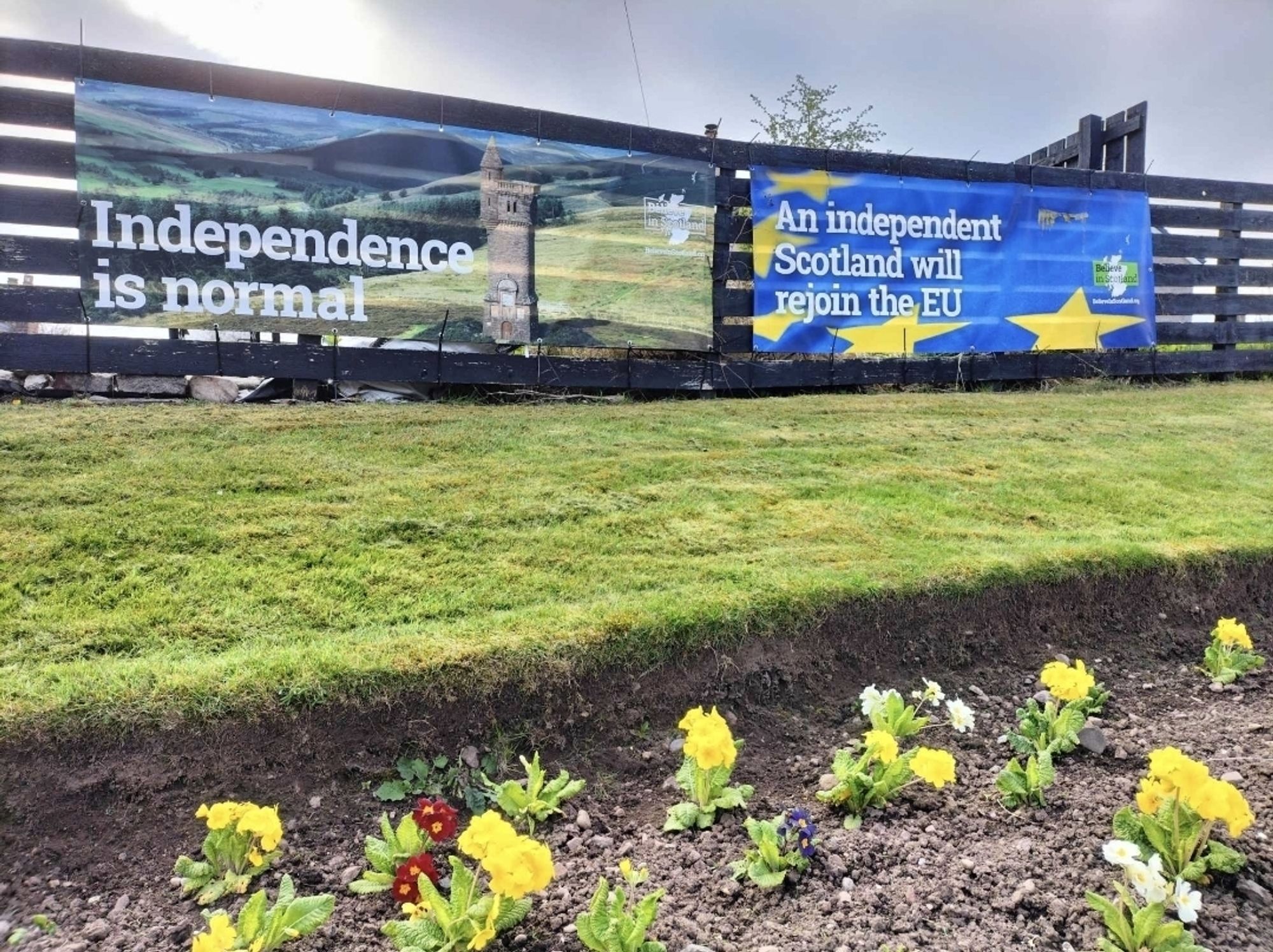 'Independence is normal' and 'an independent Scotland will rejoin EU' banners on a large fence