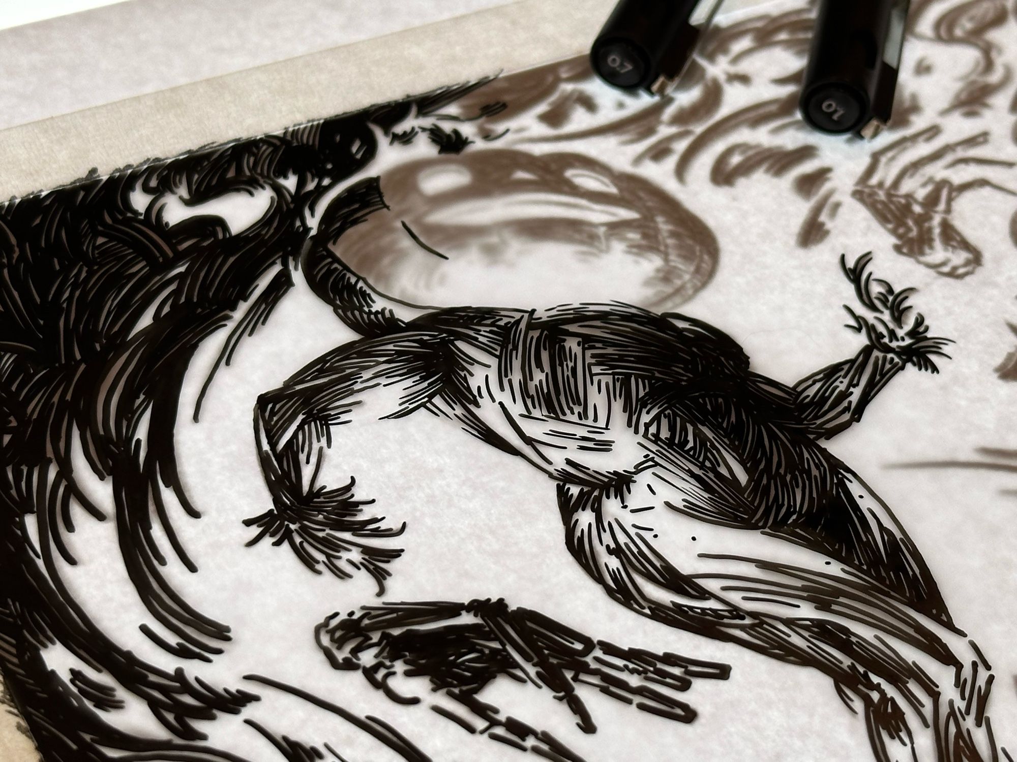 a cropped photo of a black and white drawing on a light board that is in the process of being inked. it depicts a jack-o-lantern headed figure with a straw body and floating skeletal hands, who is surrounded in flame. there are two felt tip ink pens sitting on top of the drawing.