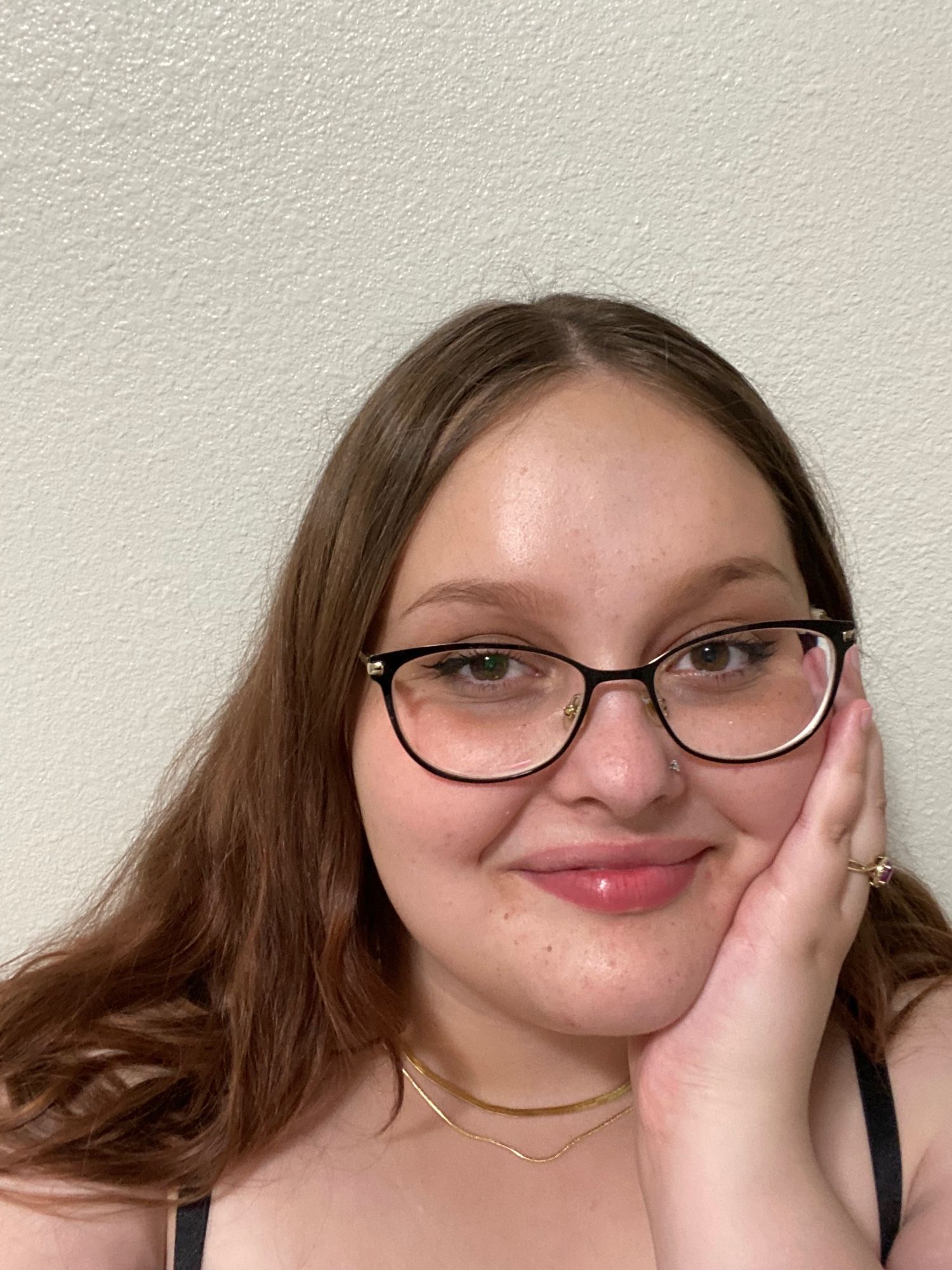 this is my cute lil selfie! i am (very) white, i have long kinda wavy brown hair, big ol’ brown eyes, and i wear glasses. here, i am wearing two overlapping gold necklaces, my gold banded ruby ring, and a black tank top shirt. nice to meet you!