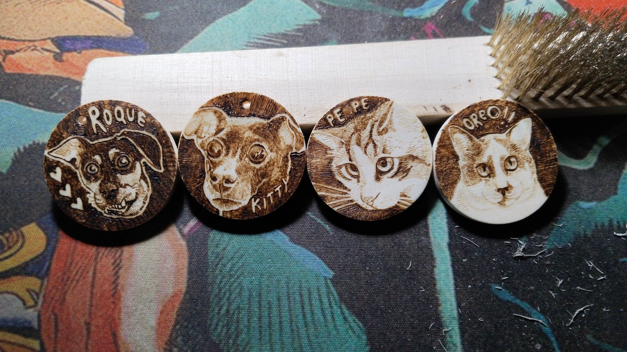 Four pyrographied little wooden circles with two dogs and two cats (Roque, Kitty, Pepe, Oreo)