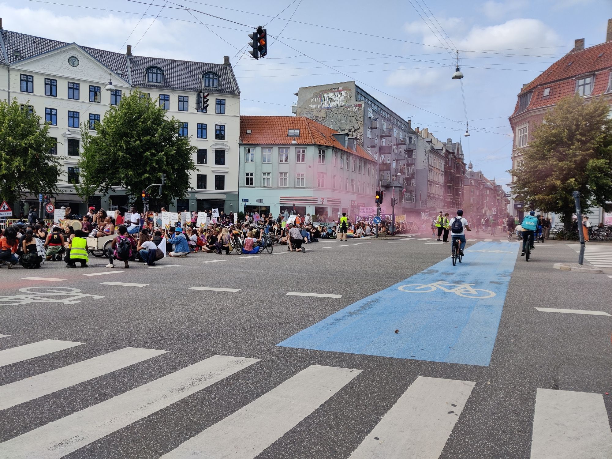 Crows sitting down in a junction. Pink smoke from a smoke canister