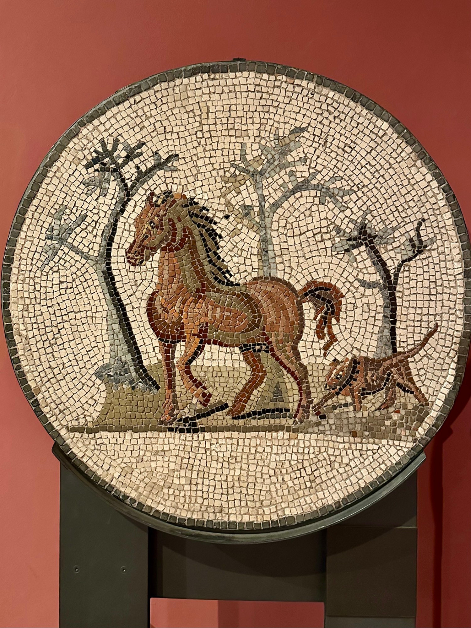 A horse & a dog, with trees in the background.

“The first pieces of the mosaic were recovered as early as 1810. The majority of the floor came into the possession of the Prussian royal family in 1880 and later the von Siemens family. Now on permanent loan to the Berlin museum.” - Museum caption