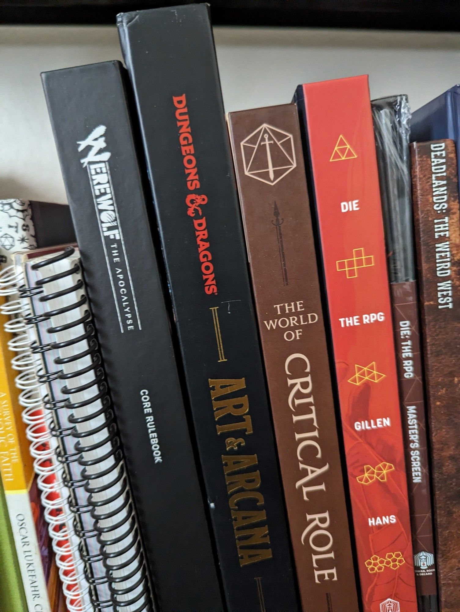 Books: werewolf the apocalypse, D&D art and arcana, the world of critical role, Die the RPG with GM screen, and Deadlands