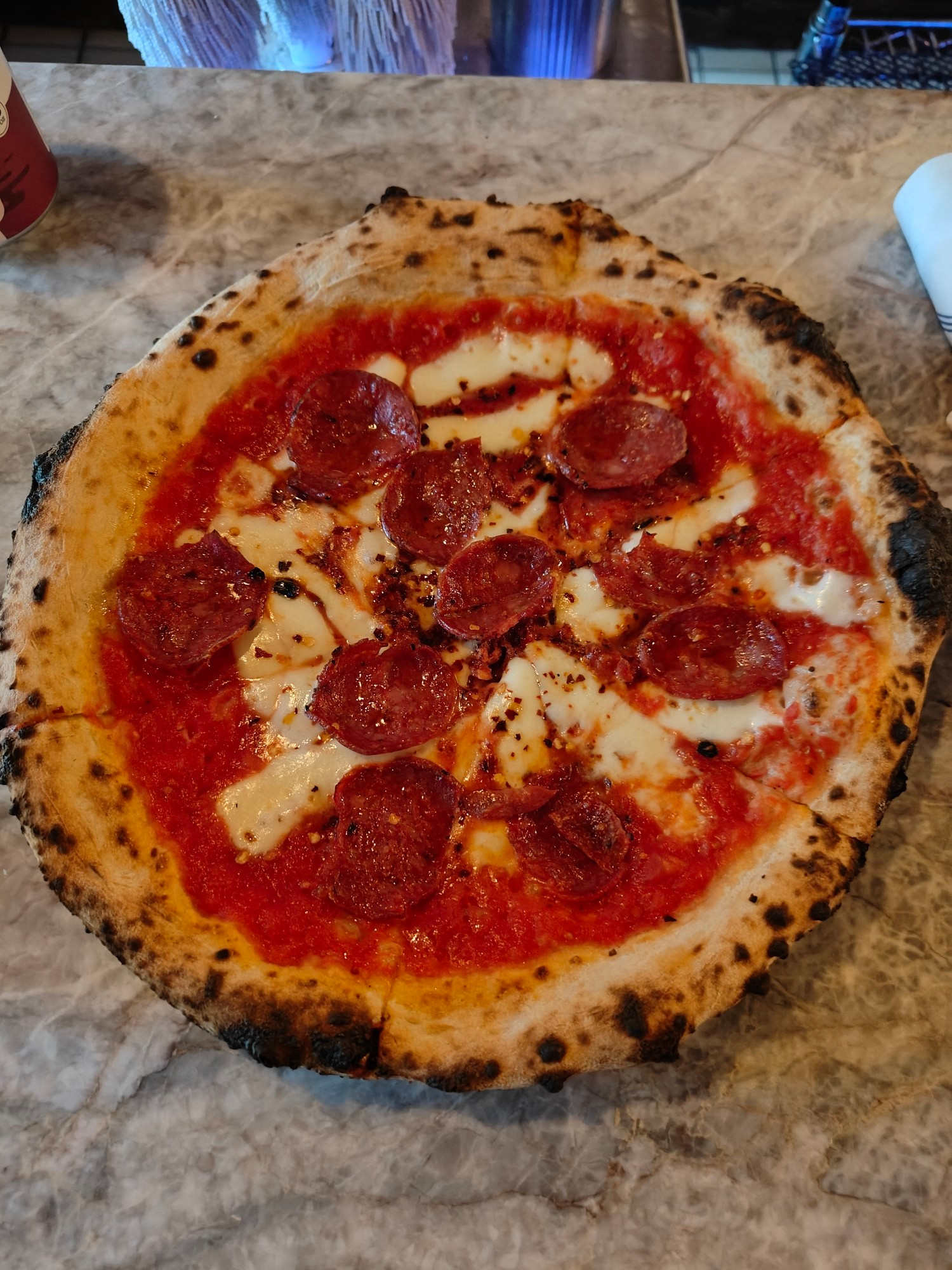 Diavola pizza - tomato sauce, fresh mozzarella, spicy salami, chili pepper, pecorino, basil