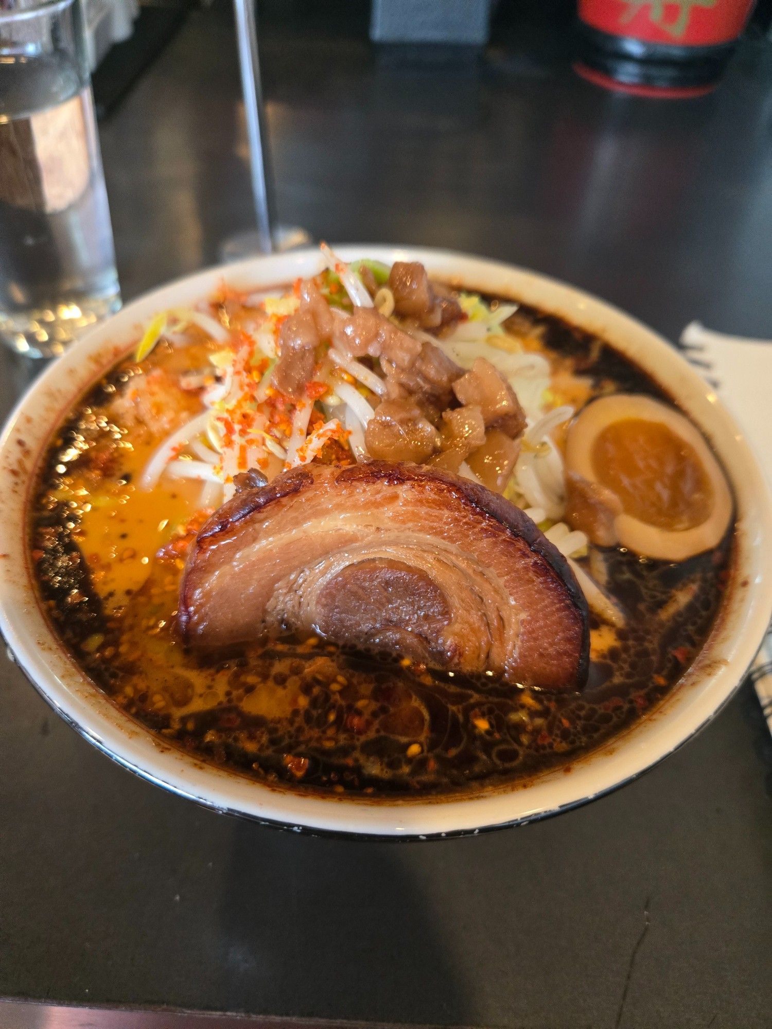 A bowl of spicy garlic chili miso tonkotsu Ramen, piled high with noodles and cabbage