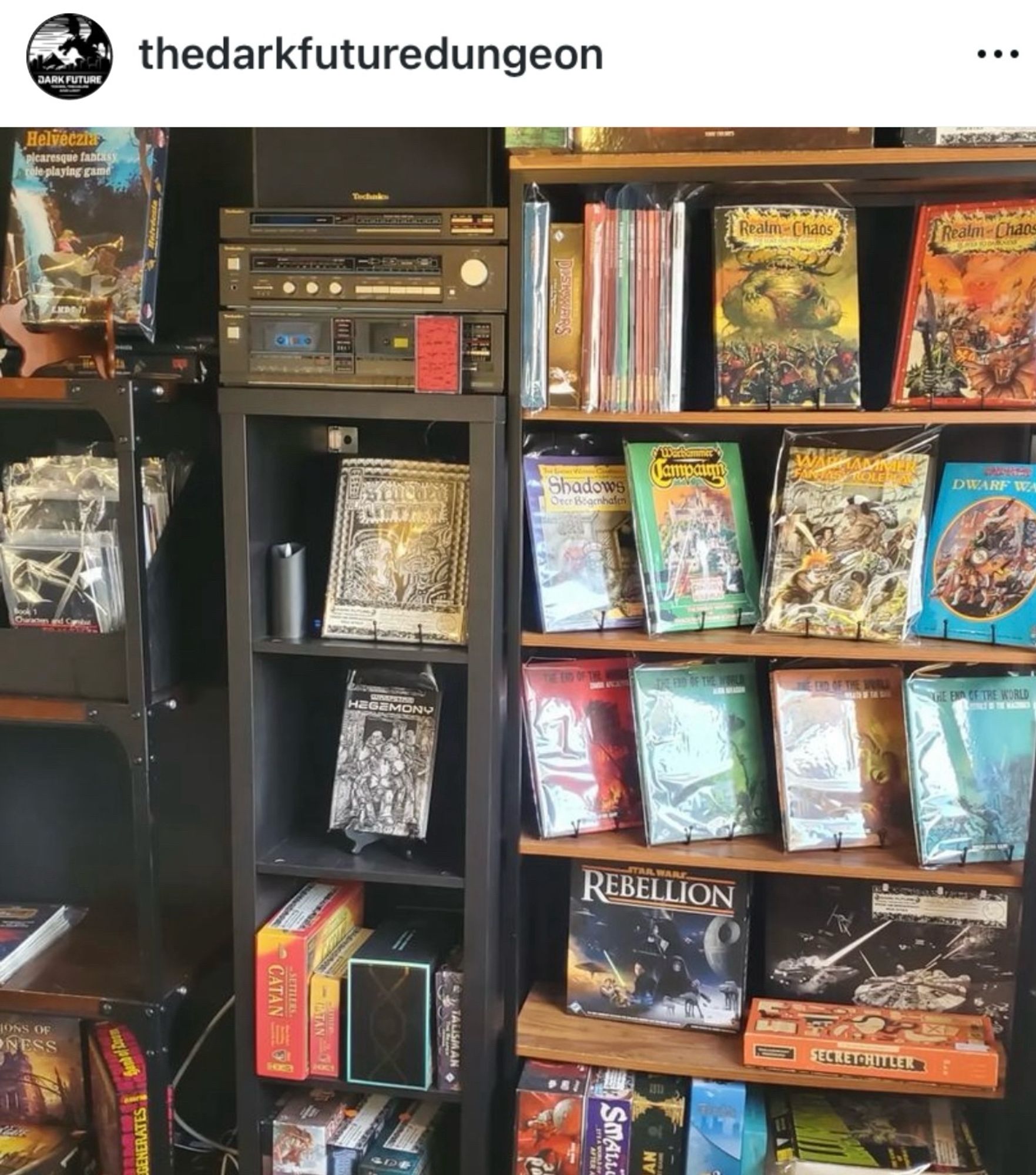 Table top gaming shop with shelves of old and new books and games