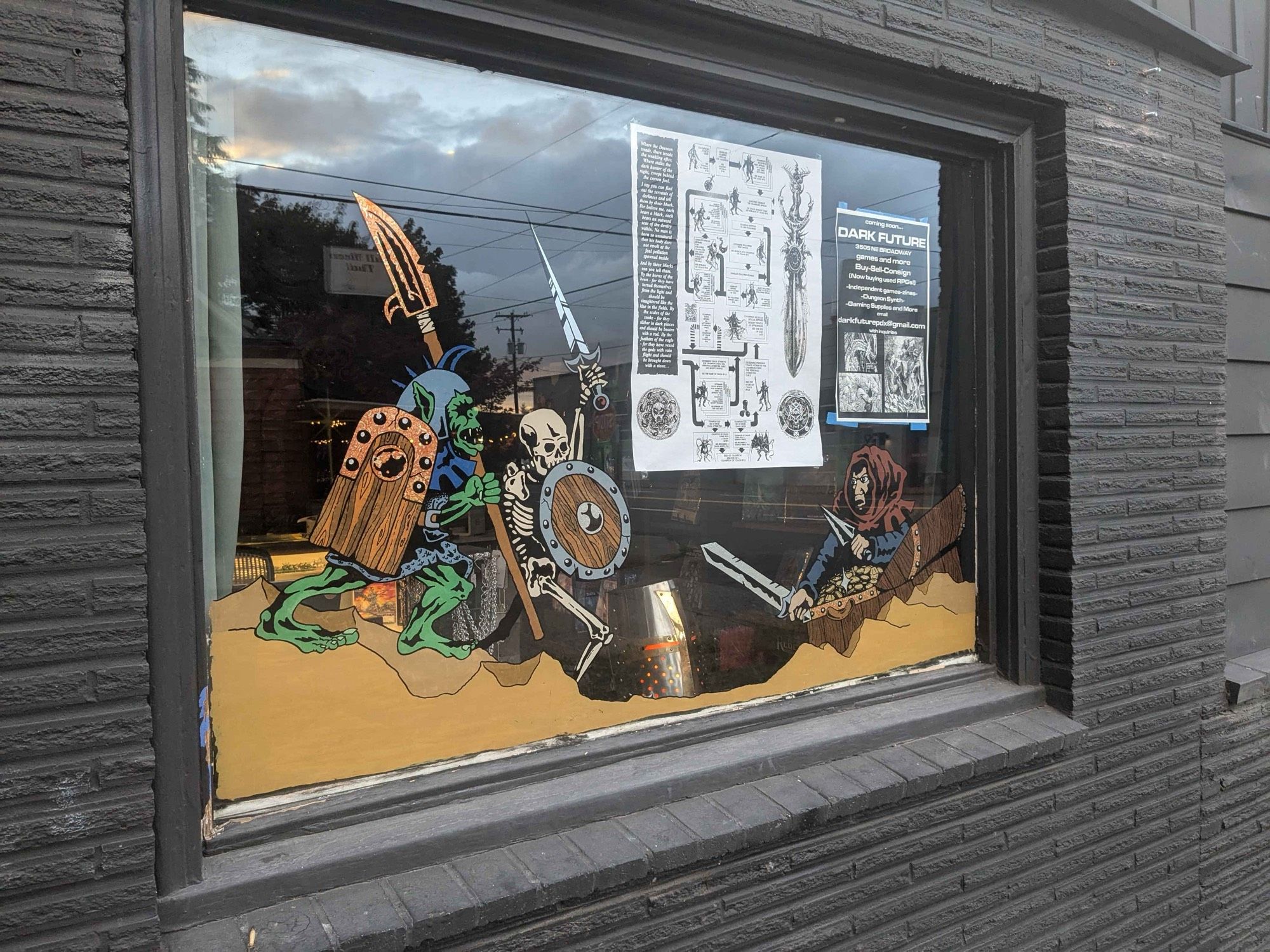 Store front window with orc, skeleton battle stuff painted on it.