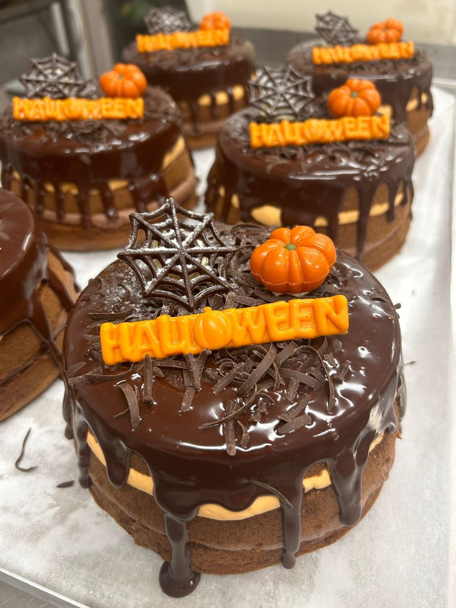 Een chocolade dripcake, met oranje Halloween-decoraties.