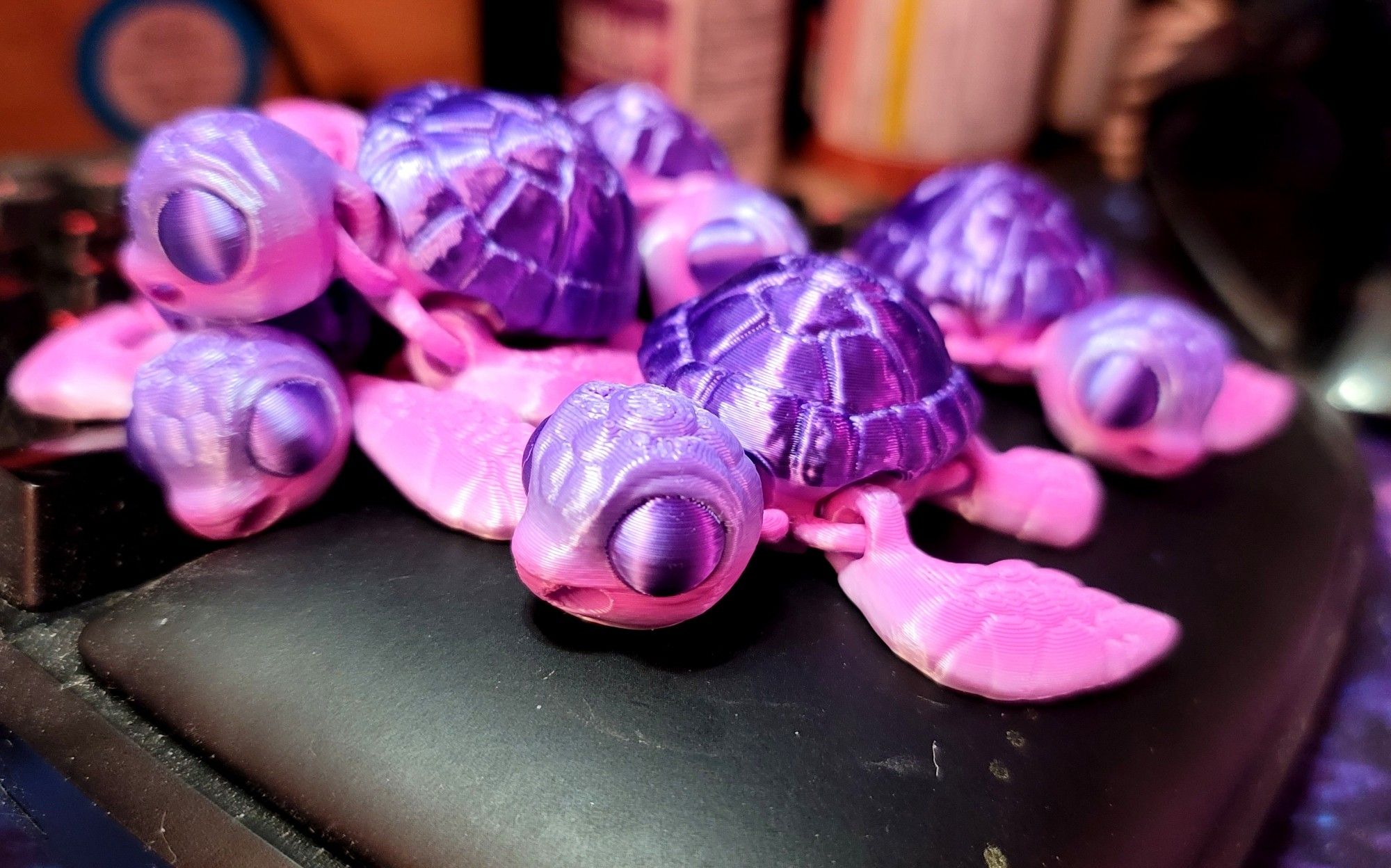 A bunch of tiny turtles with pale pink bodies slowly fading into pale purple, and bright purple shiny shells