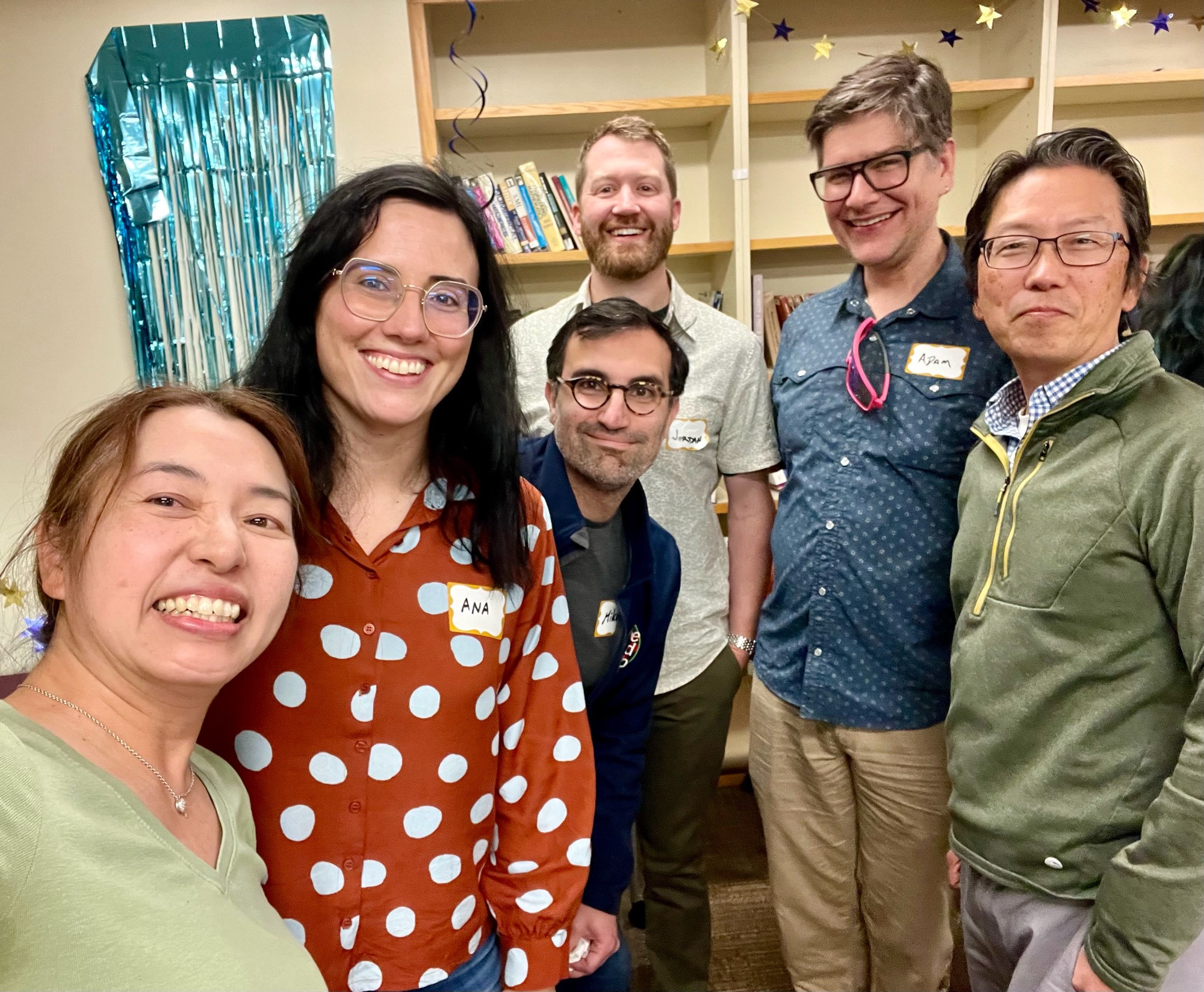 Six people are pausing for a photo in a conference room.