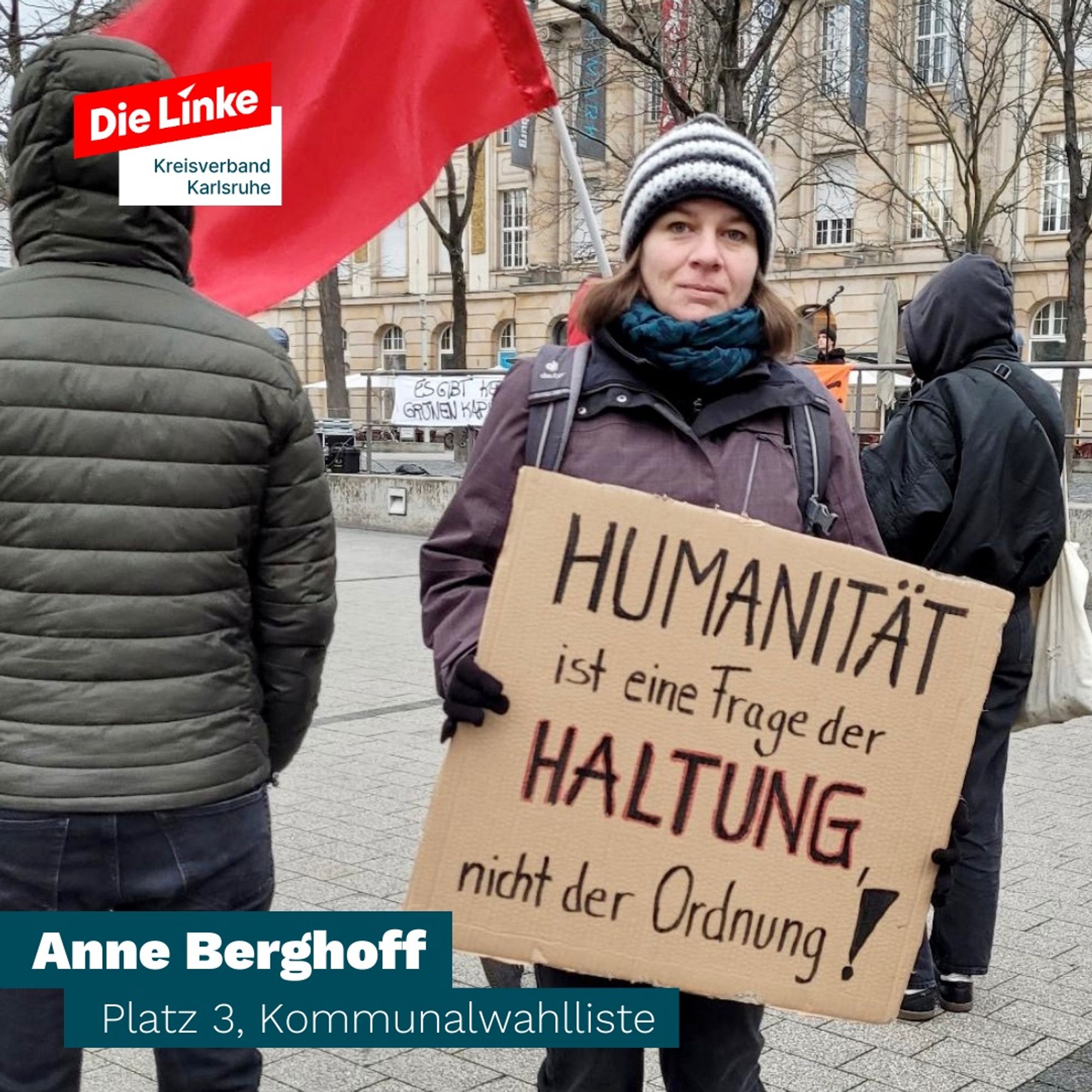 Anne Berghoff (Die Linke Karlsruhe) mit Schild „Humanität ist eine Frage der Haltung, nicht der Ordnung“