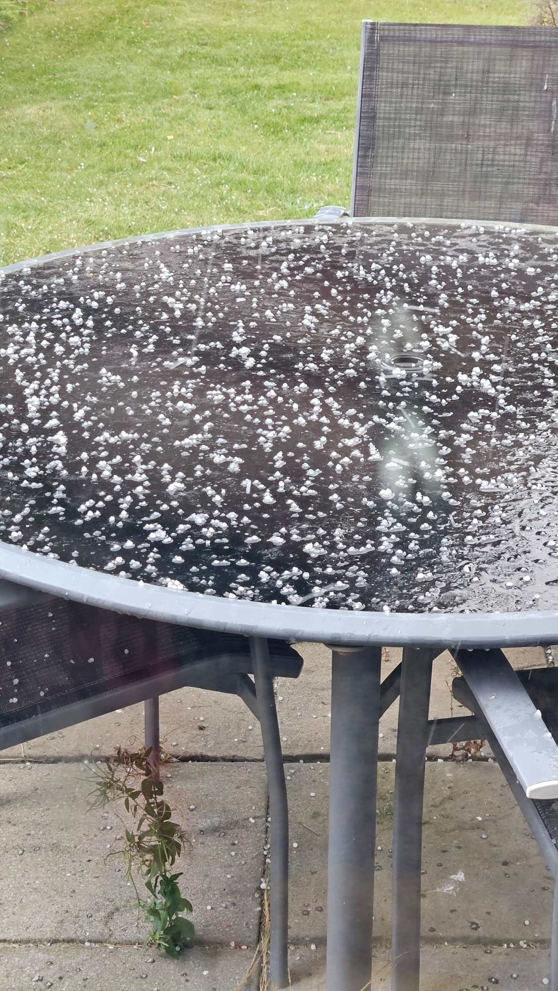 Garden table covered in hailstones.