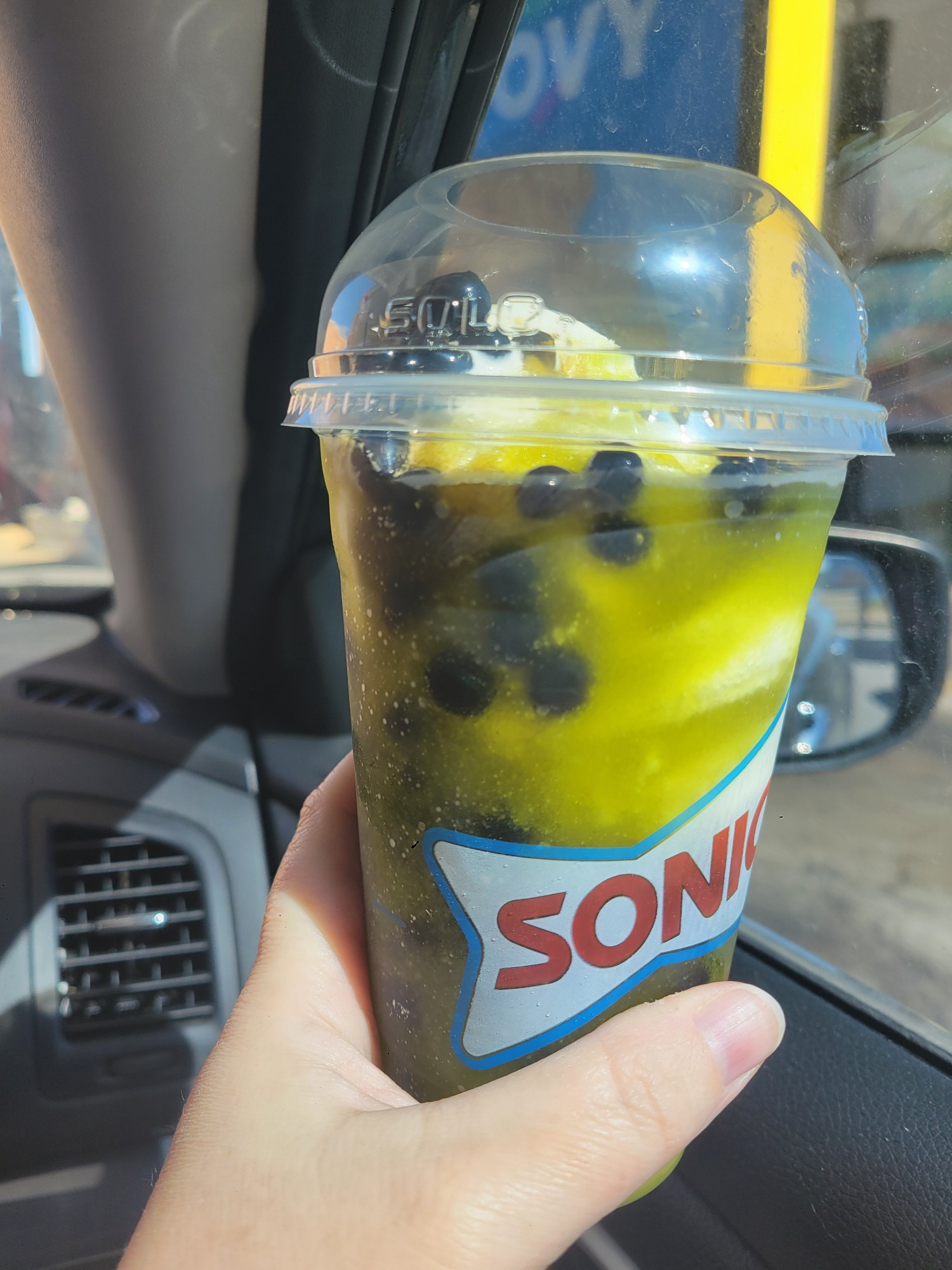 A green slush from sonic with soft serve and popping boba 