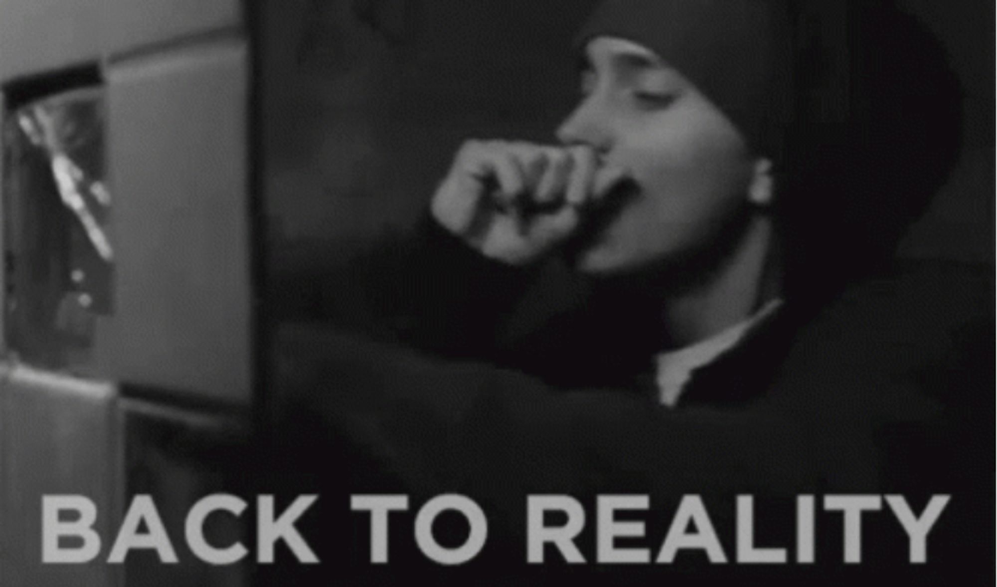 black-and-white photo of rapper Eminem, image mood is shadowed and grim. Text below says "back to reality"