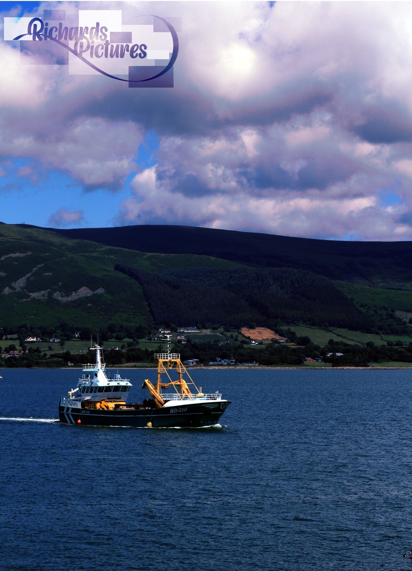 Boat in the middle of the water. Carlingford mountains in the background.