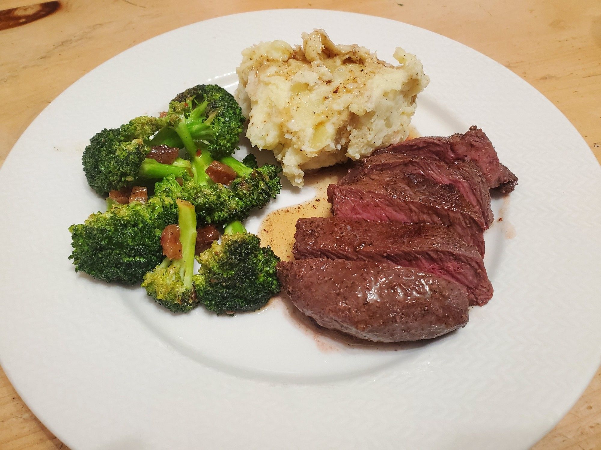 Steak and mashed potatoes with garlic pan sauce and broccoli with chopped dates.