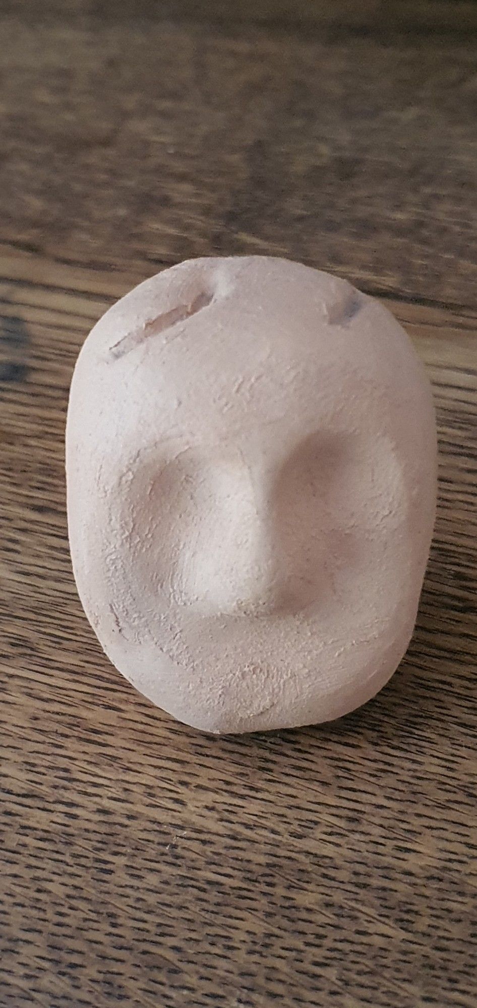 Kleine Tonskulptur.
Mongesicht mit Narben oben auf dem Kopf.
Narben duch Shunt Implantation.