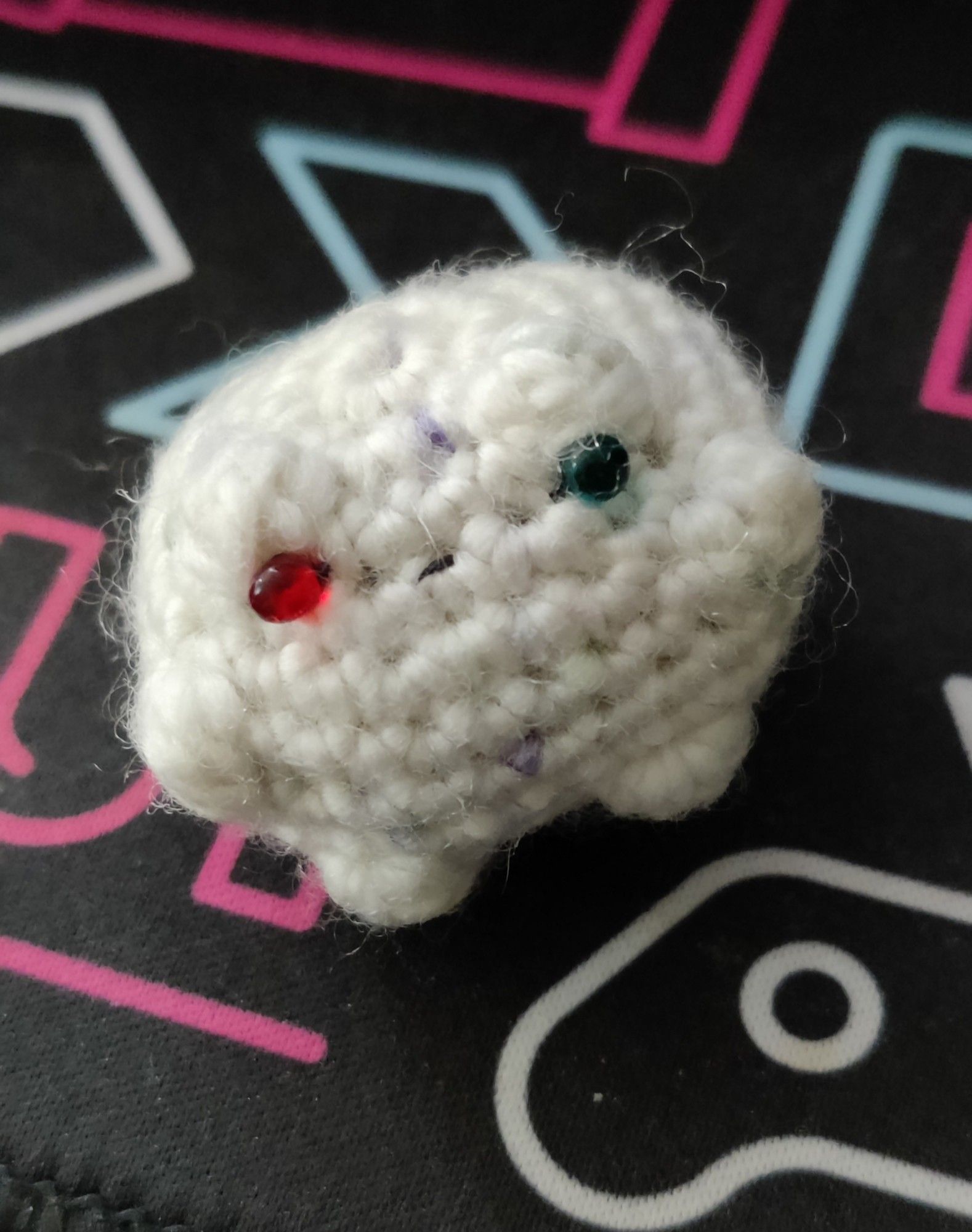 Tiny woven frog butt with blue and red eye beads