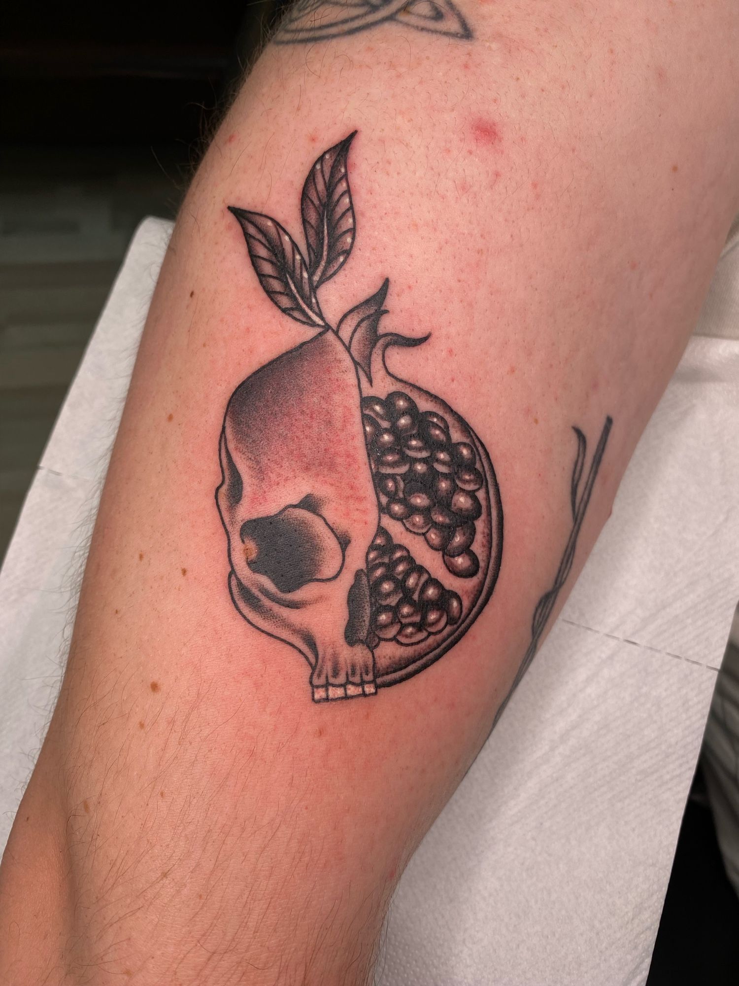 Half skull, half pomegranate tattoo