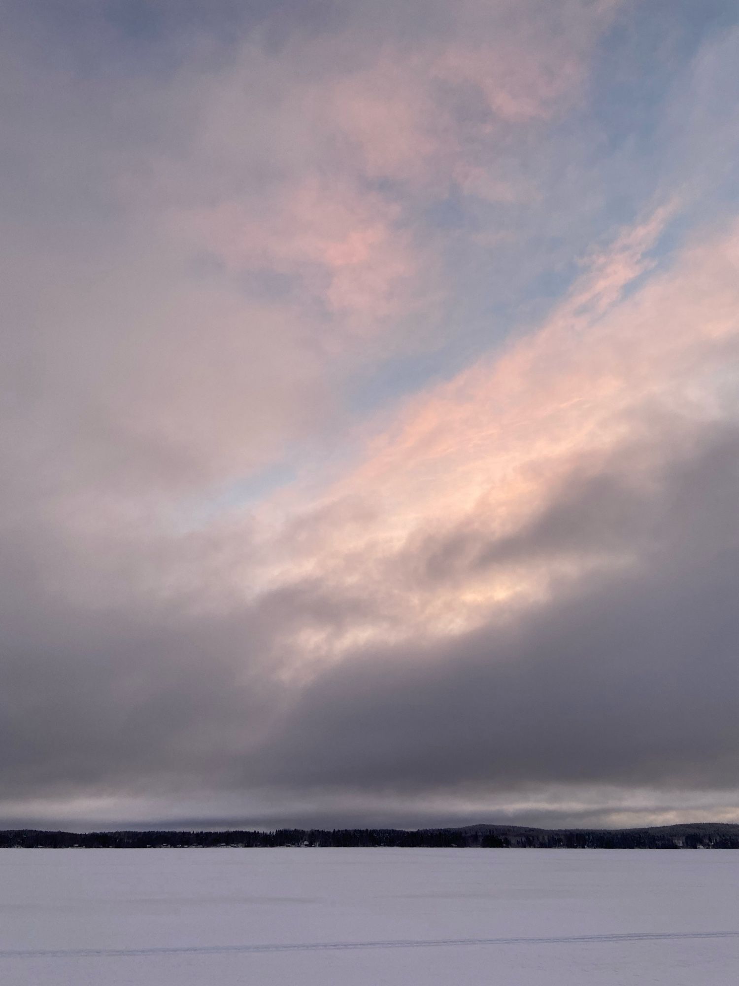 Aamu alkaa valjeta järvellä. Tumma pilvi on siirtynyt sinisen ja vaaleanpunaisen taivaan tieltä.