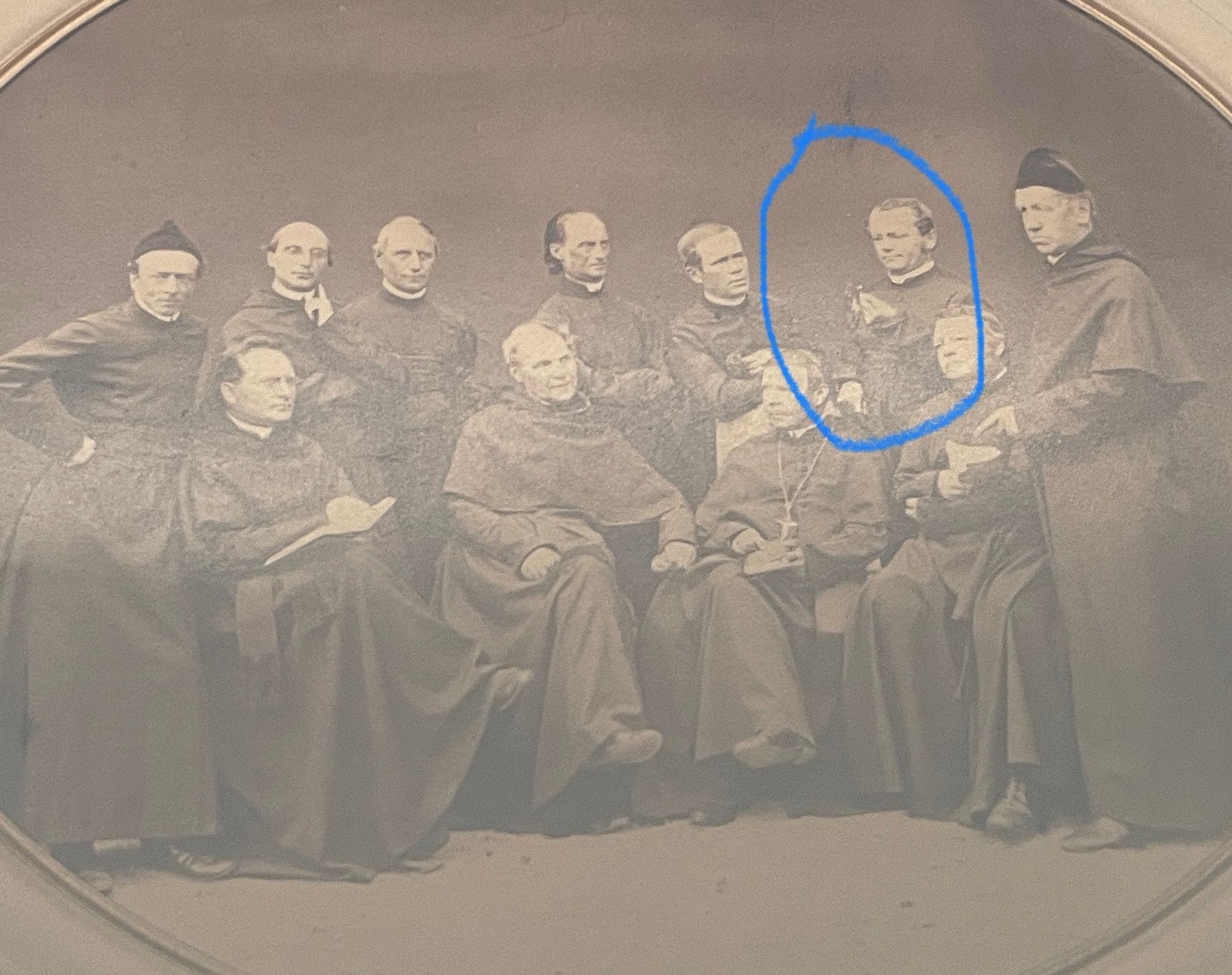 Group photo of Augustinian monks with mendel looking at a little plant and being the center of attention