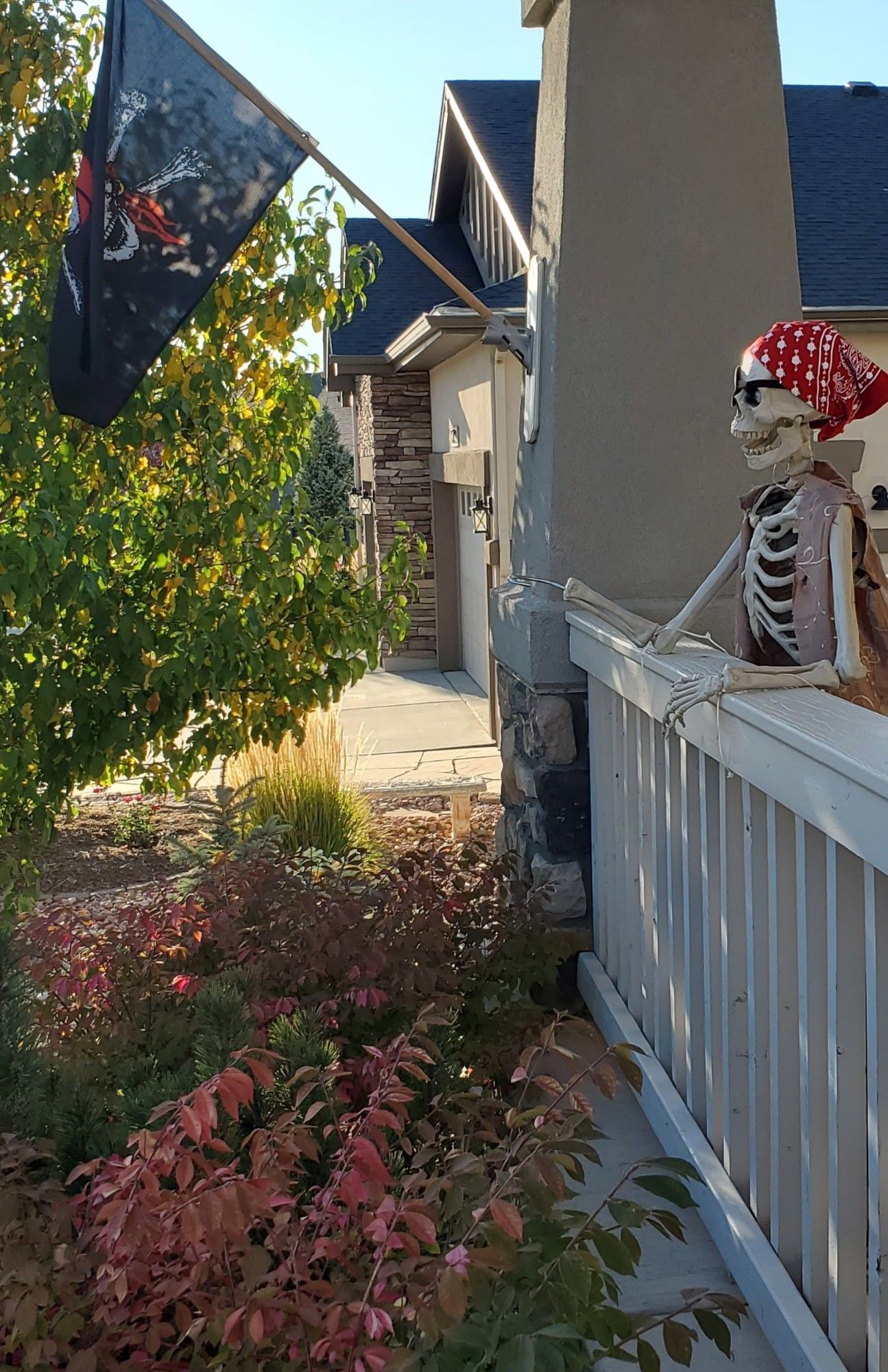 Skeleton pirate standing on a porch under a pirate flag.