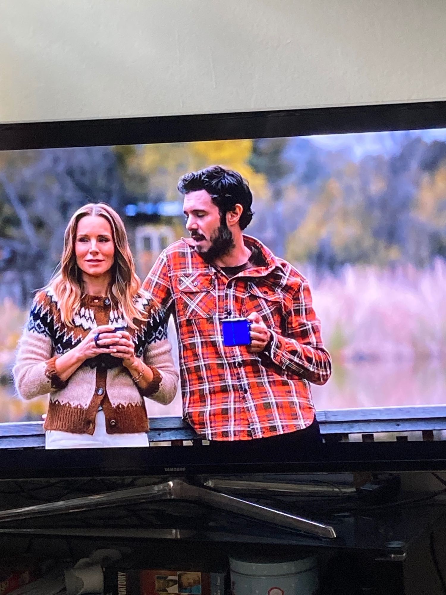 Kristen Bell wearing a great brown beige zigzag cardigan and Adam Brody wearing a fab red checked lumberjack shirt