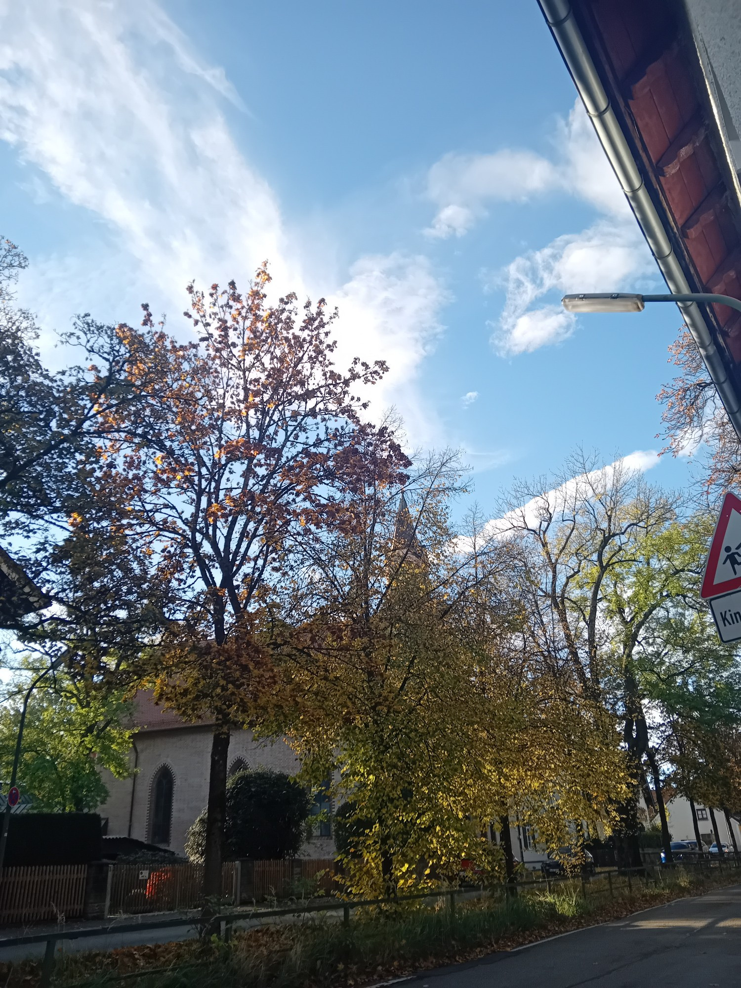 Kirche in Altperlach. Davor die verfärbten Bäume  