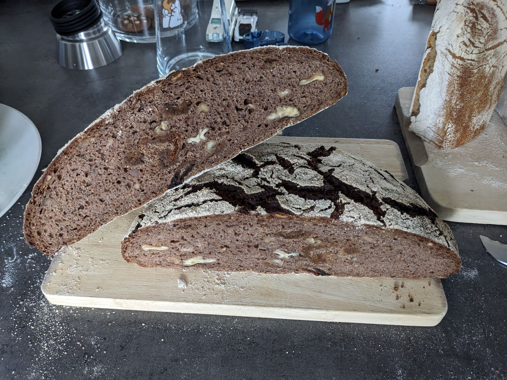 Dark cut surface of the bread with visible pieces of walnuts and figs and medium sized pores.