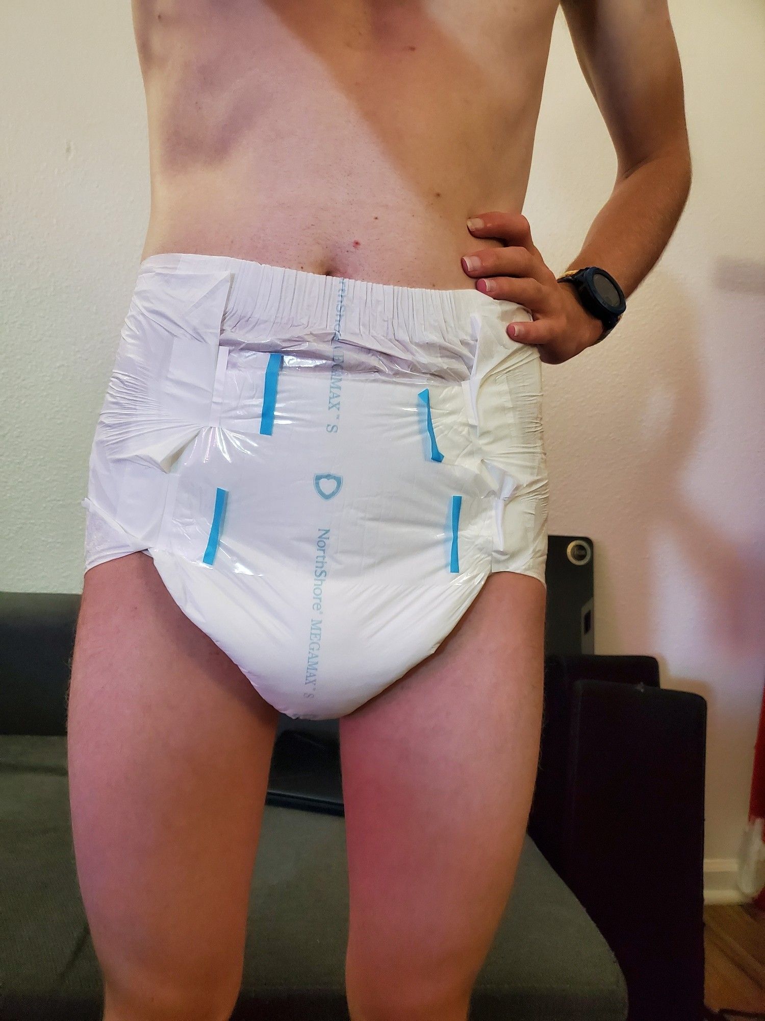 A boy standing in a slightly oversized and disproportionately thick white diaper taped slightly askew.

#abdl #irldiaper