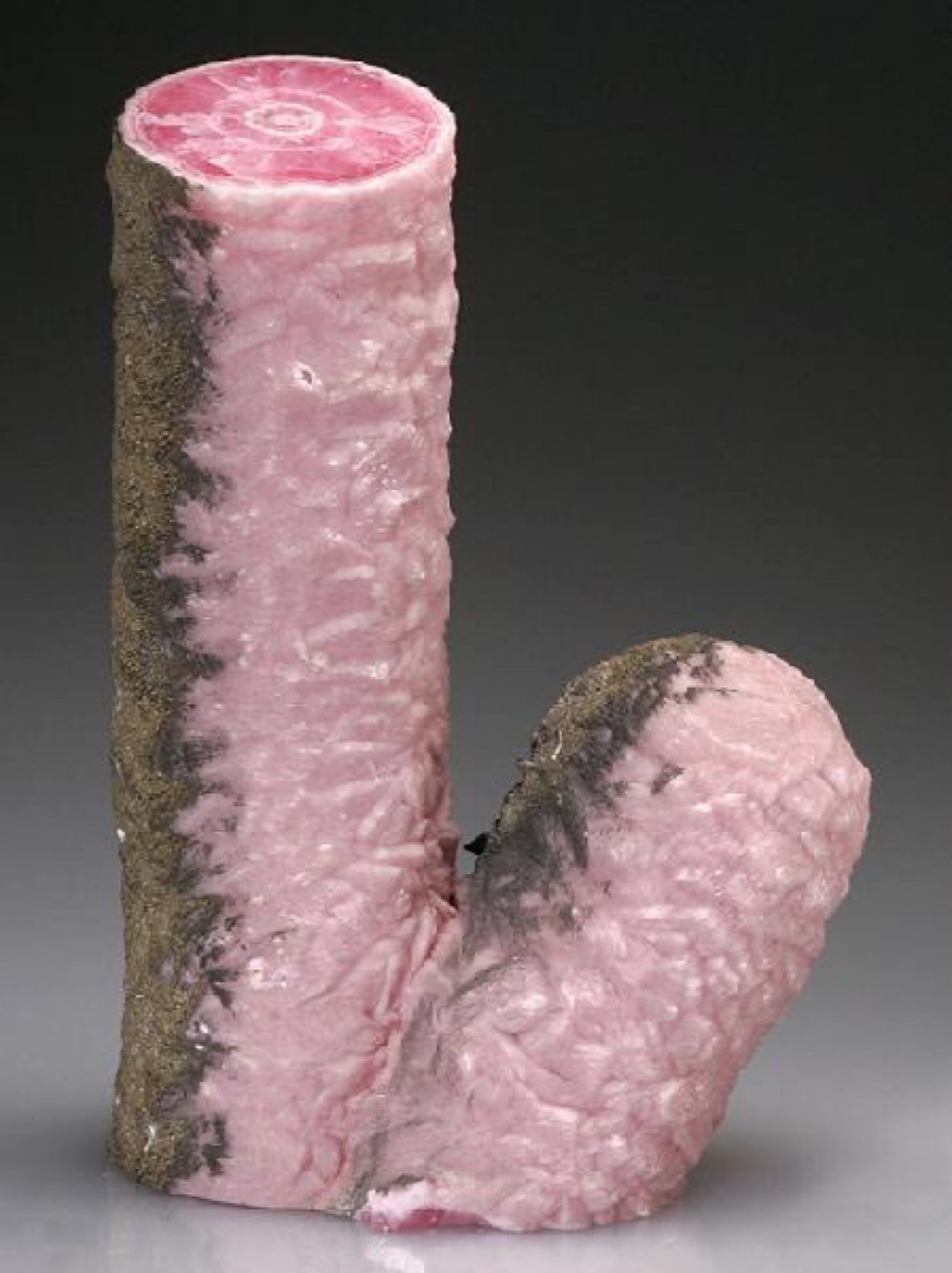 Pink crystal shaped suspiciously like cock and balls, but with a flat tip. The upper surface is weathered brown