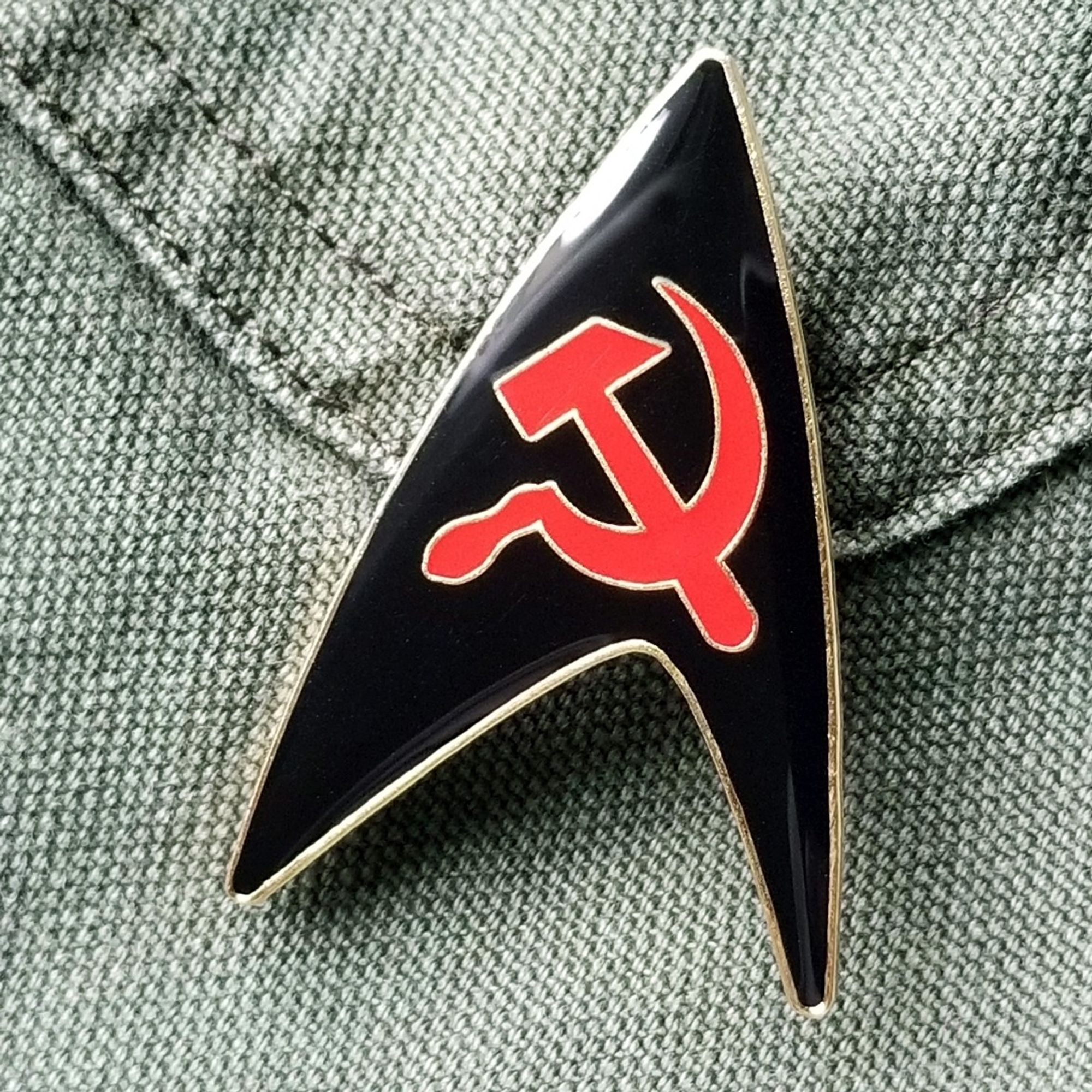 A black Starfleet delta insignia pin with a red hammer and sickle in the center, with gold trim and a high gloss finish.