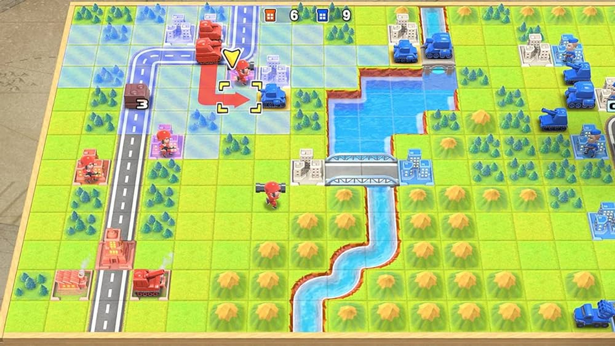 A screenshot of Advance Wars on the Nintendo Switch. Brightly painted plastic tanks in red and blue face off against each other atop a grid map with terrain like roads, hills, and urban areas.