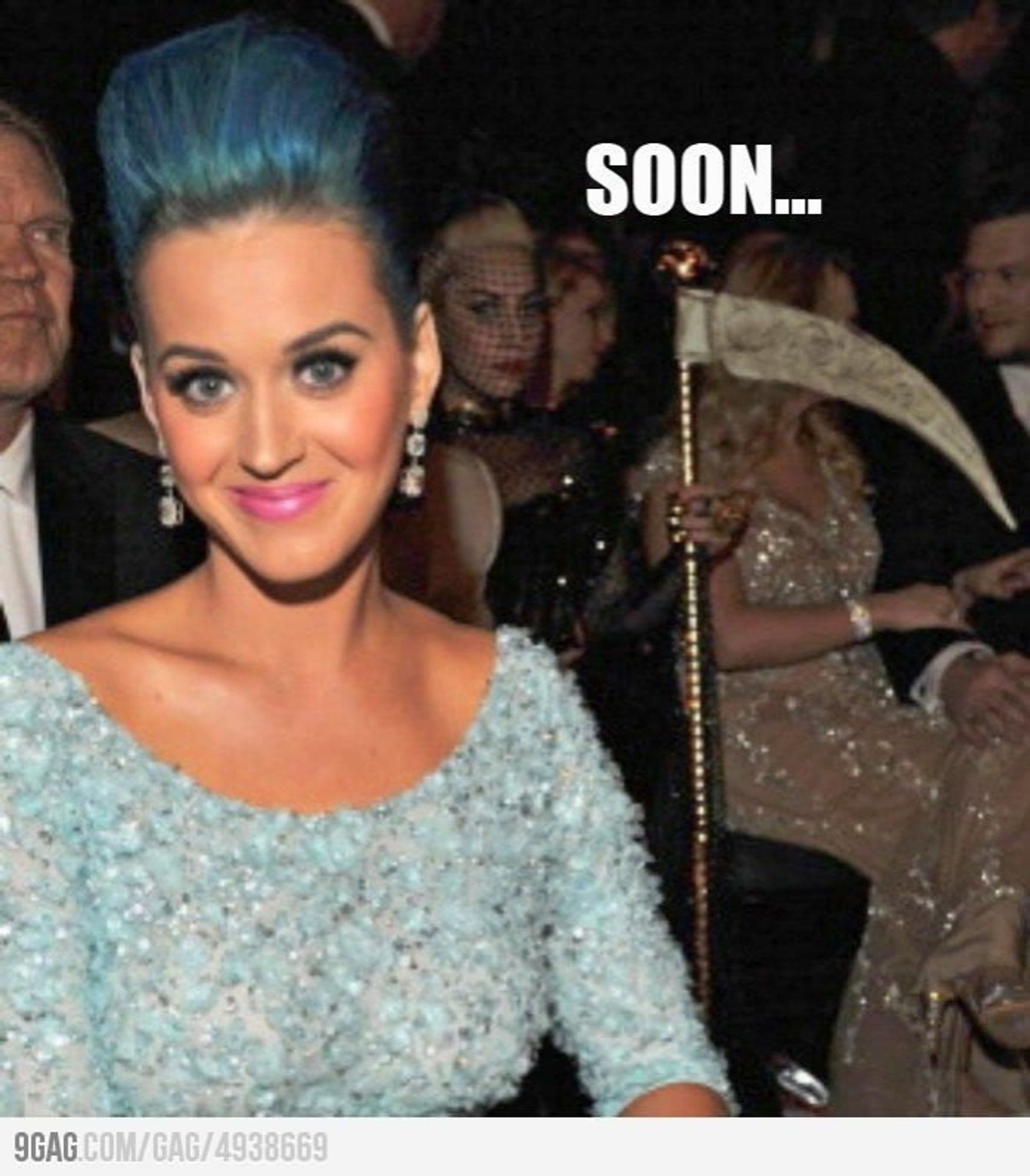 A 'retro' meme of a photo of Katy Perry at an award show with Lady Gaga stealing the shot from behind holding a golden scythe, captioned "Soon..."