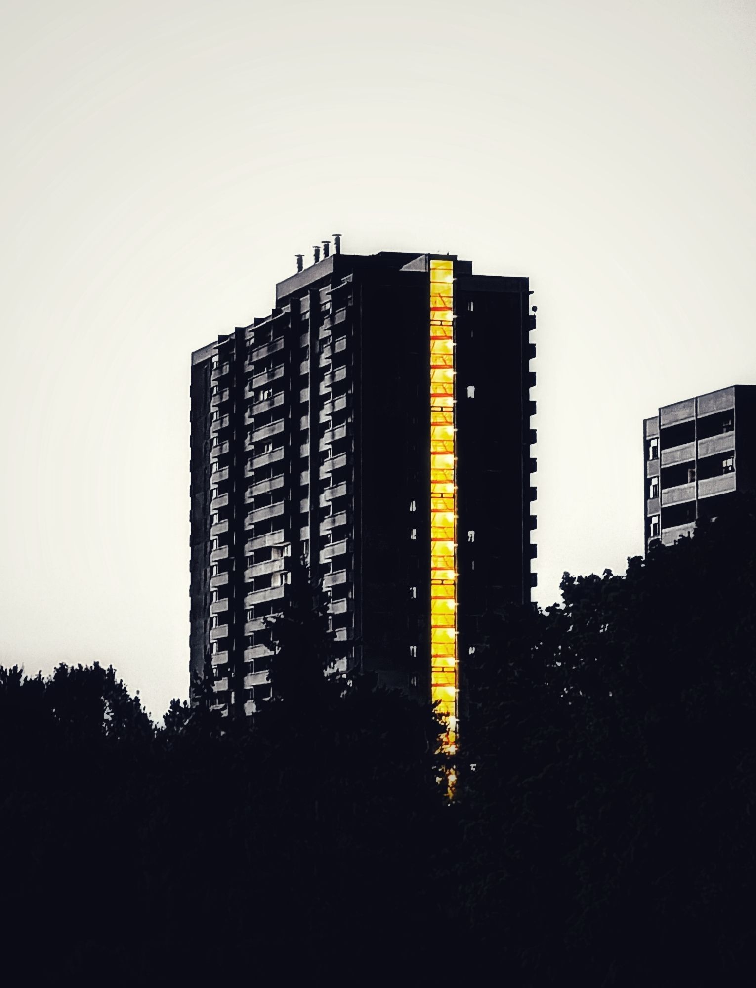 Day 4219 - Light Your Way
High contrast black and white image of an apartment building with the stairwell glowing yellow as a colour pop I think it's called