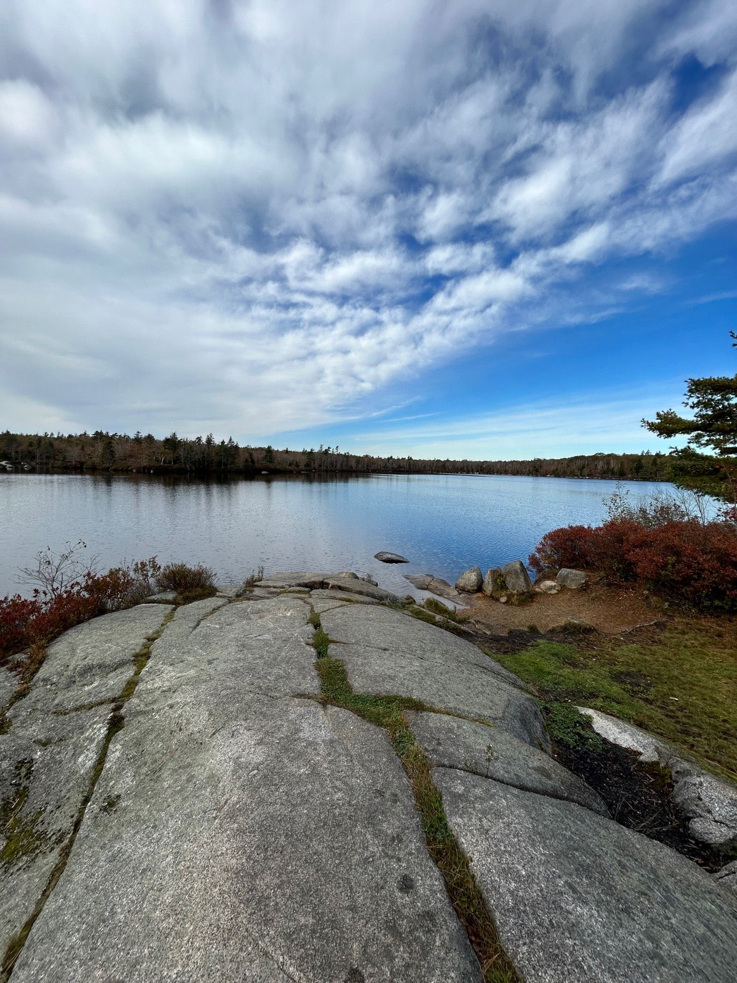 Standing on a rock overlooking a lake with a blue skyline