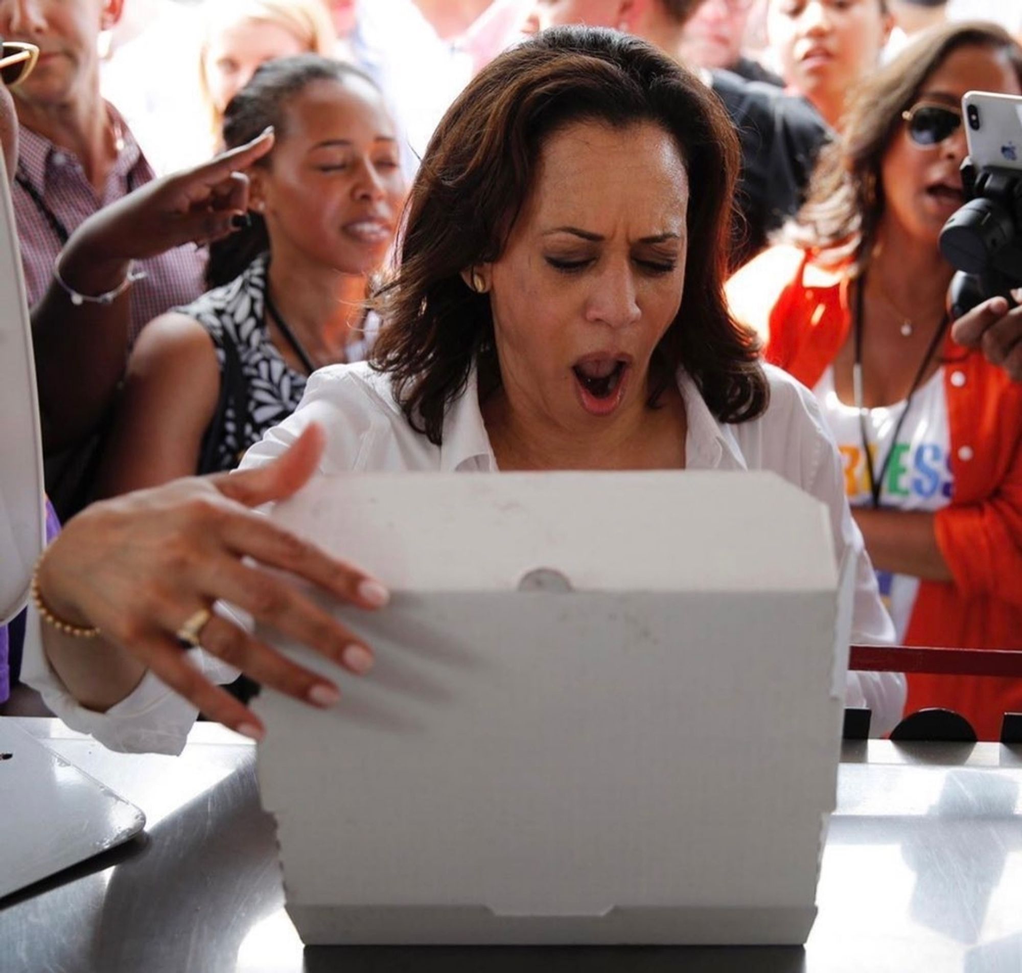 Kamala Harris opening a box and looking excited