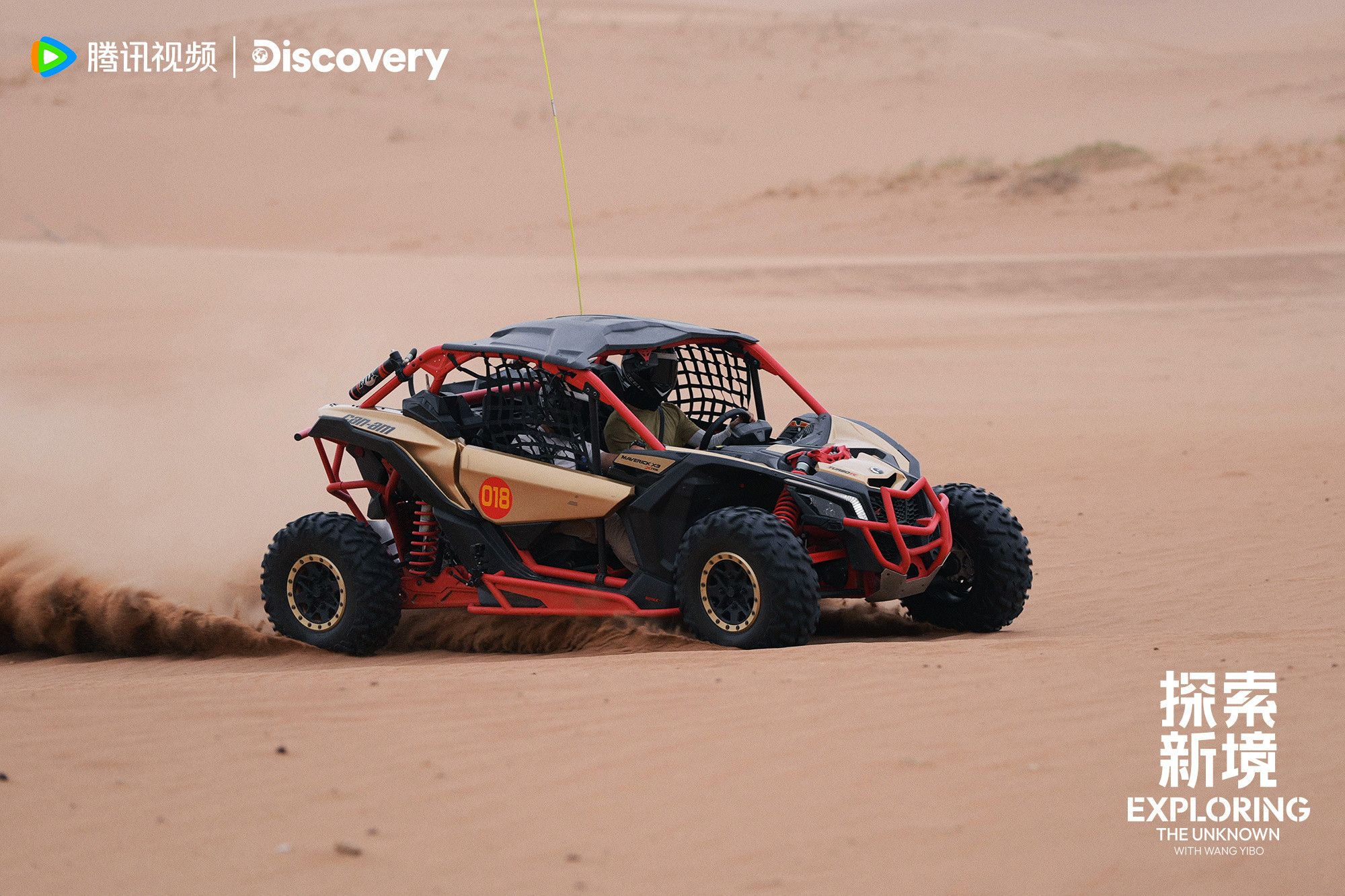 a small red framed dune buggy speeding along, casting up sand behind it, #WYB at the wheel.