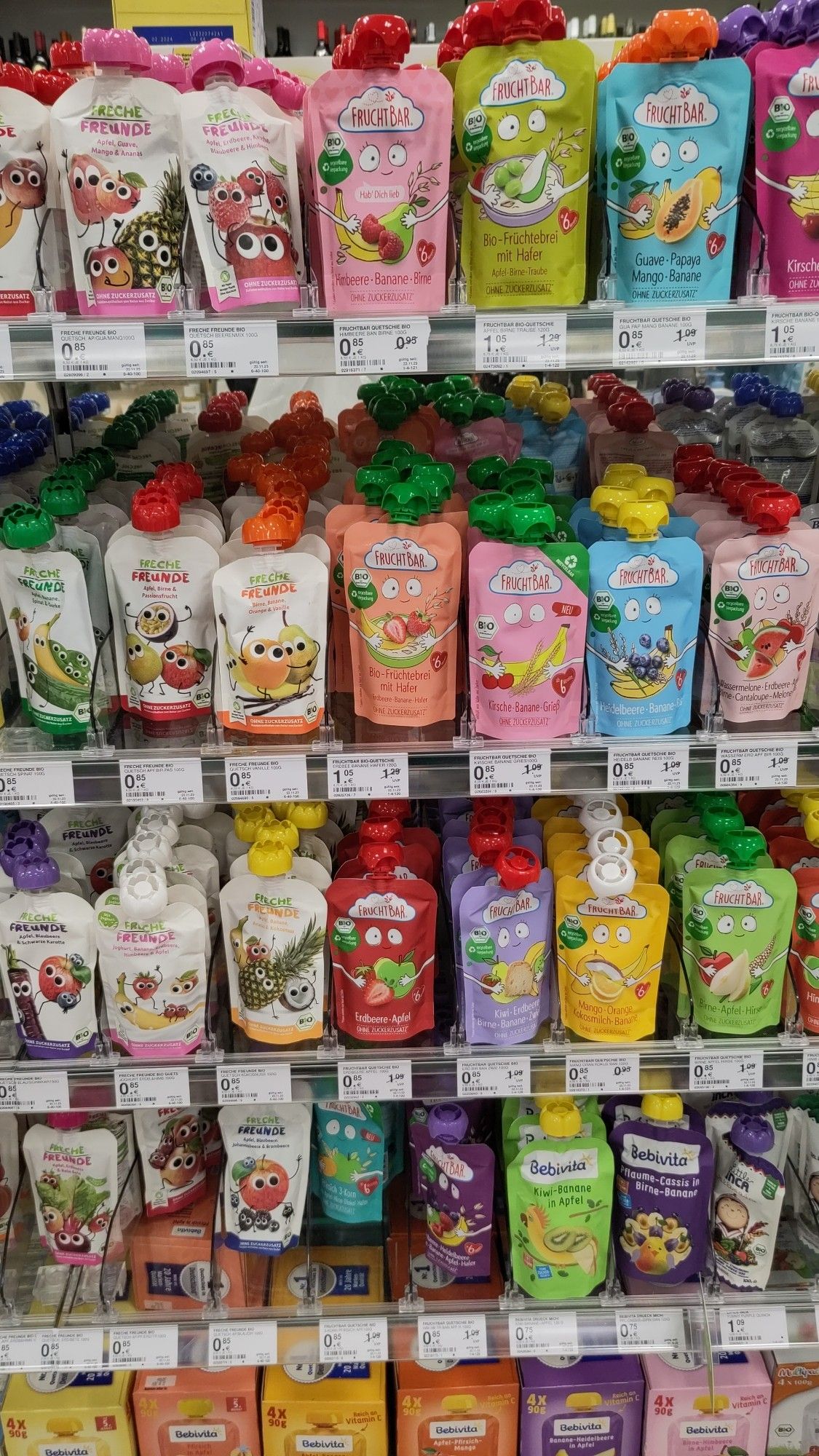 Regal mit Fruchtzubereitungen für Kinder in kleinen Plastiksäcken mit Plastikdeckeln.