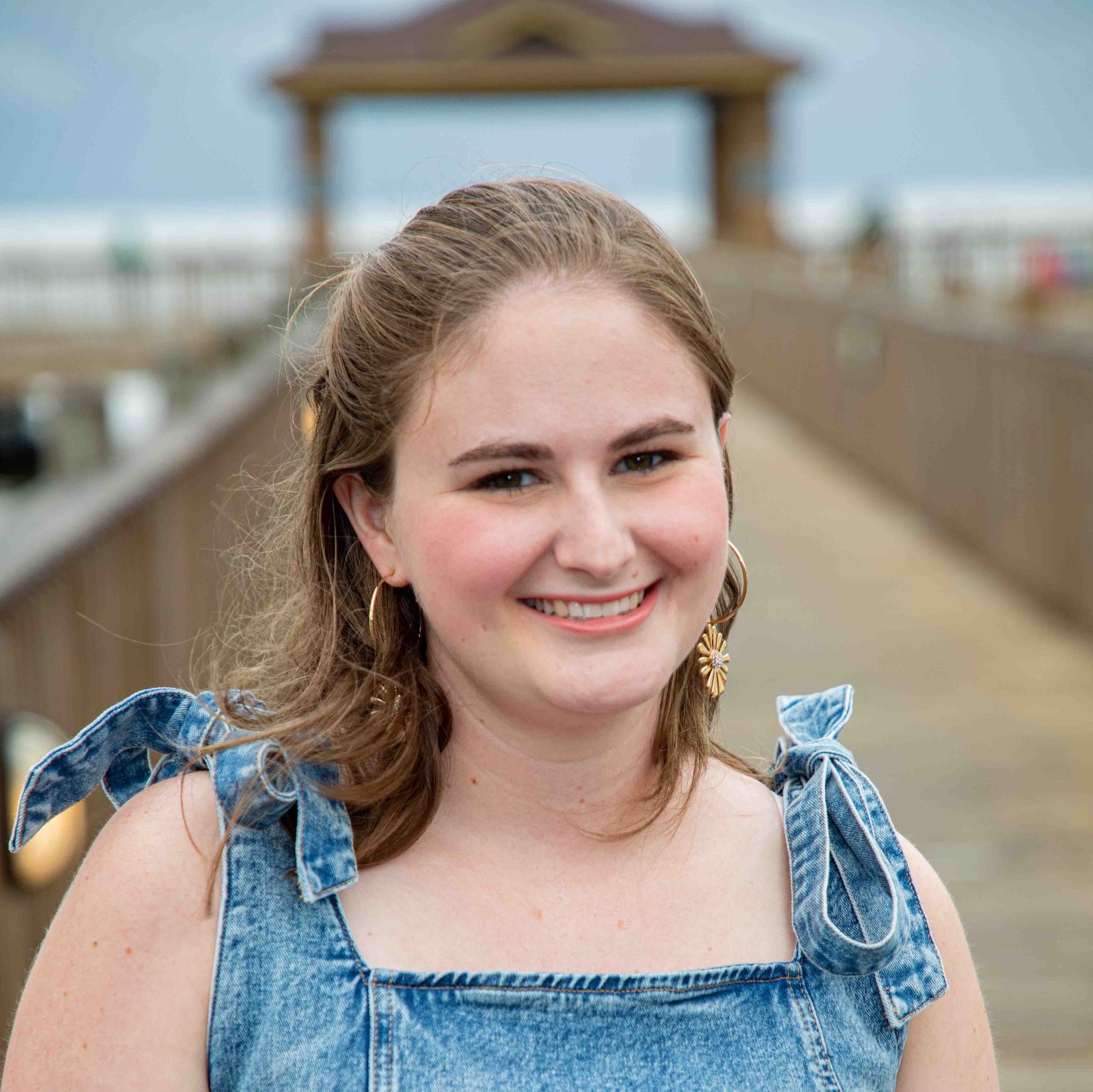 Woman in denim sundress on wood bridge (Afan Swan headshot)