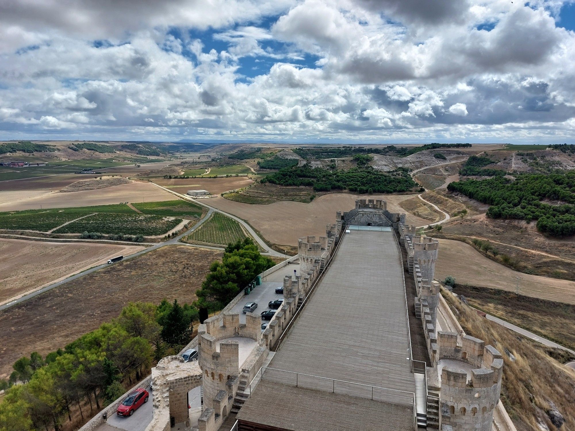 A landscape view with a line of fluffy cumulus clouds all forming at the same altitude