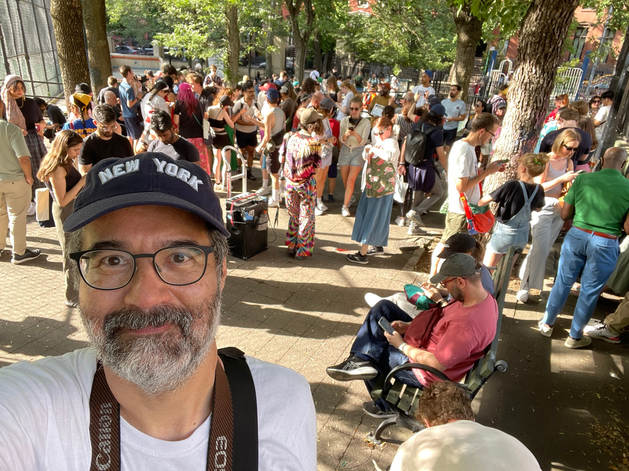 selfie of Greg Pak at the James J Walker Park - buncha people doing the Mamdani scavenger hunt behind him