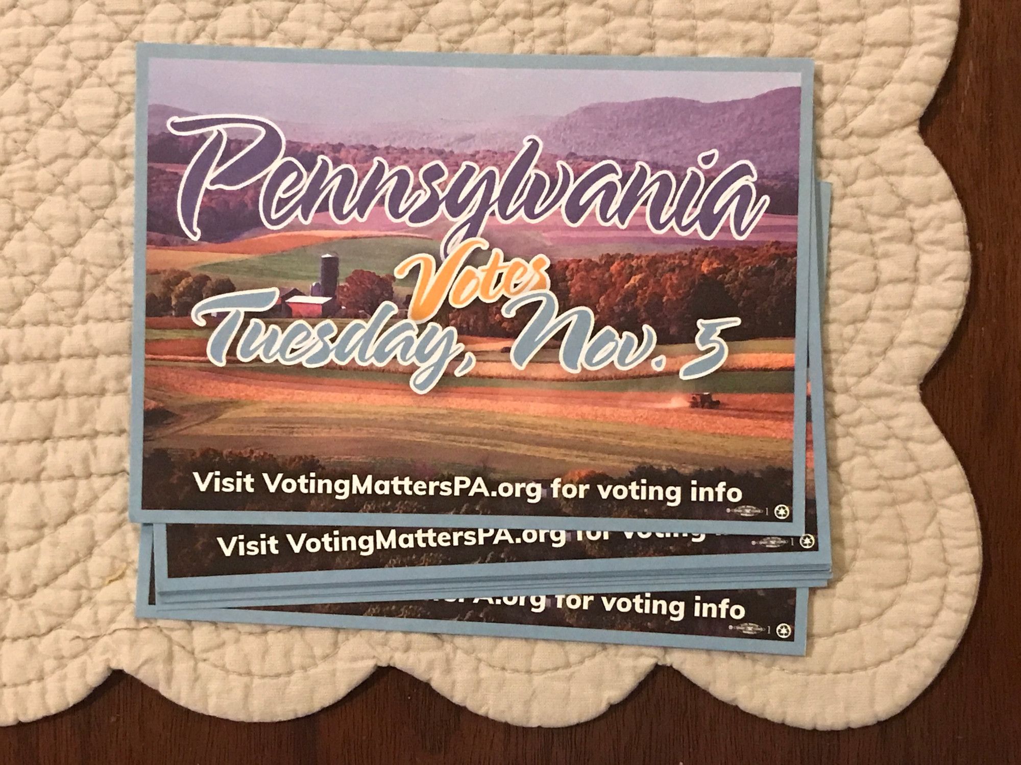 A few postcards reading "Pennsylvania Votes Tuesday, Nov 5 / Visit VotingMattersPA.org for voting info" against an image of farmland.