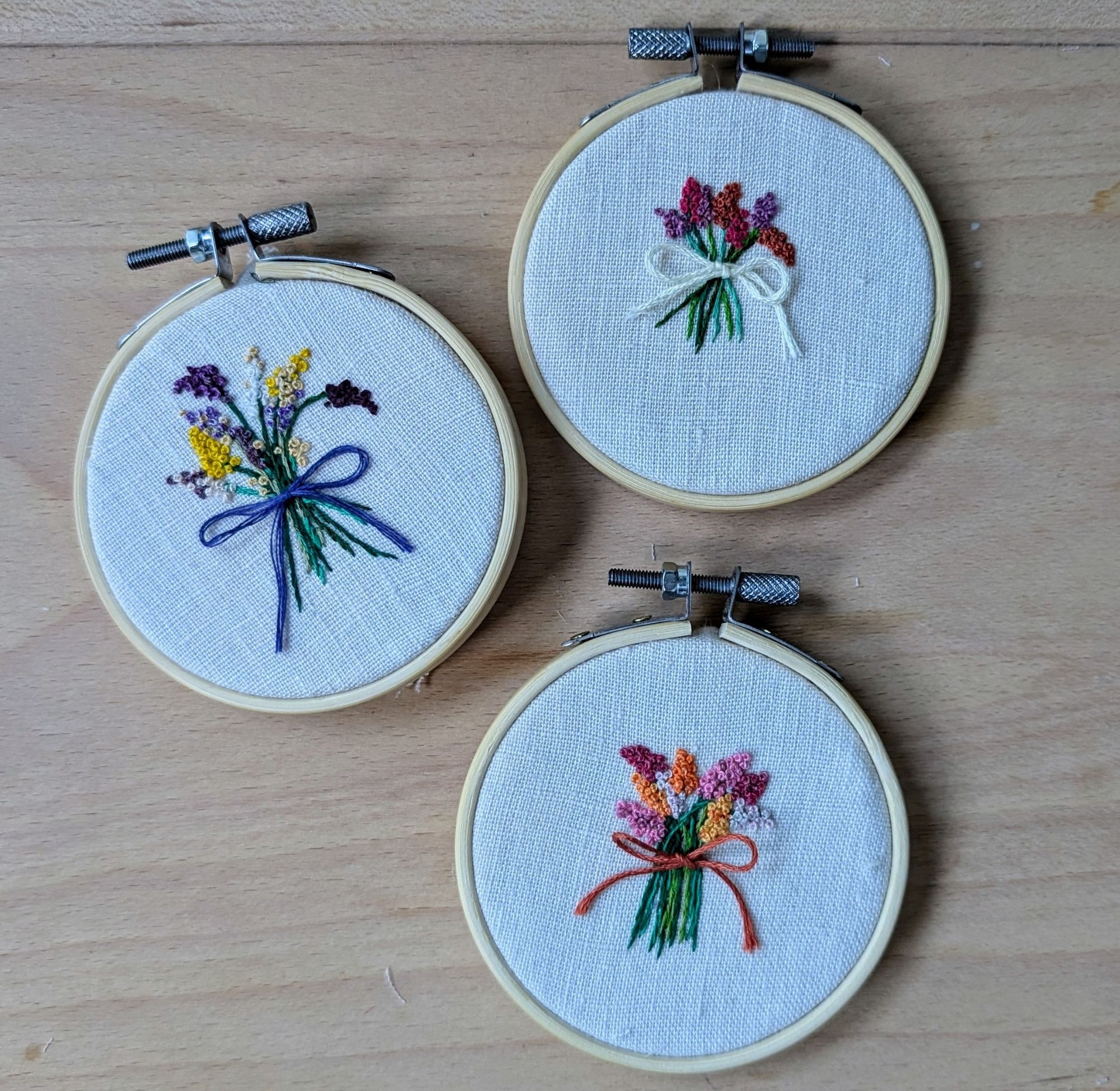 Three pride flag inspired floral embroideries on linen