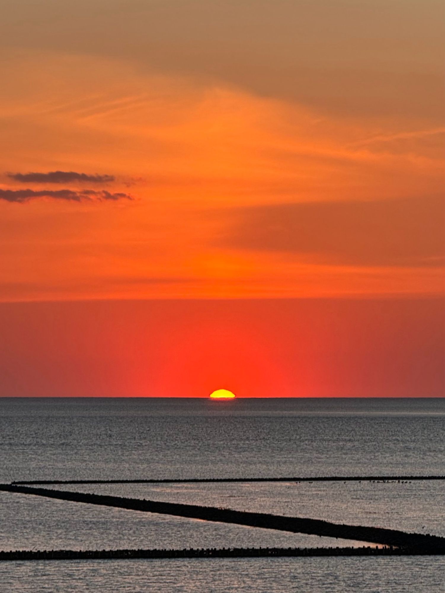 Ein Sonnenuntergang über dem Meer in Orange und Rot.