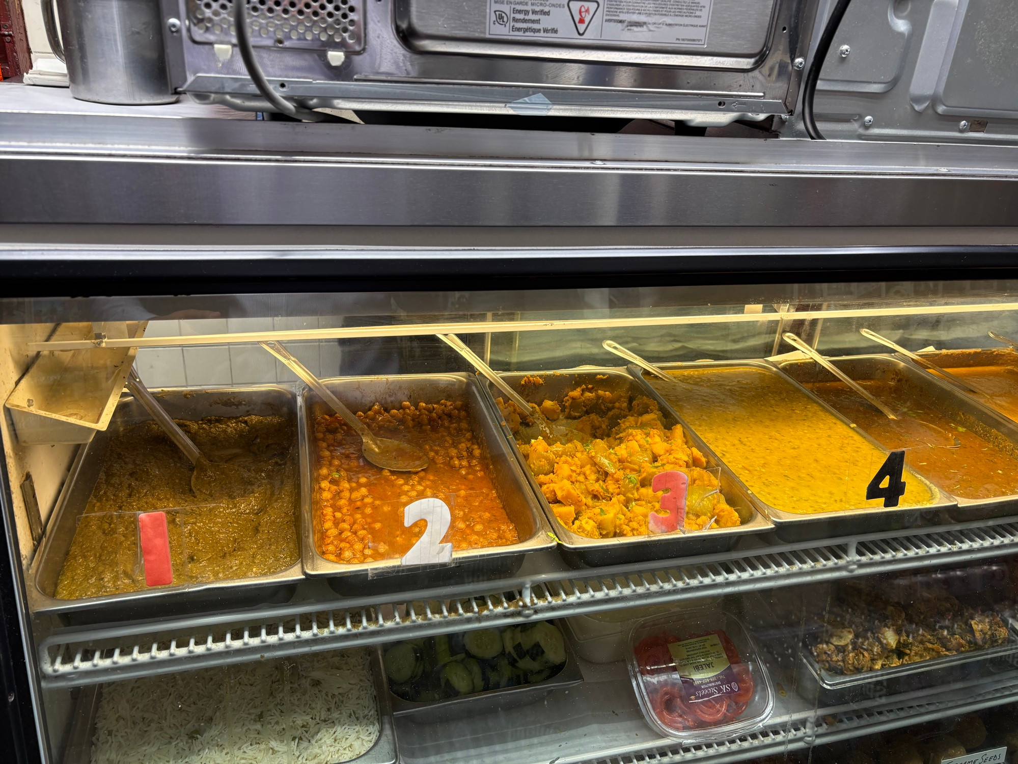 Trays of food behind glass, each of them numbered.