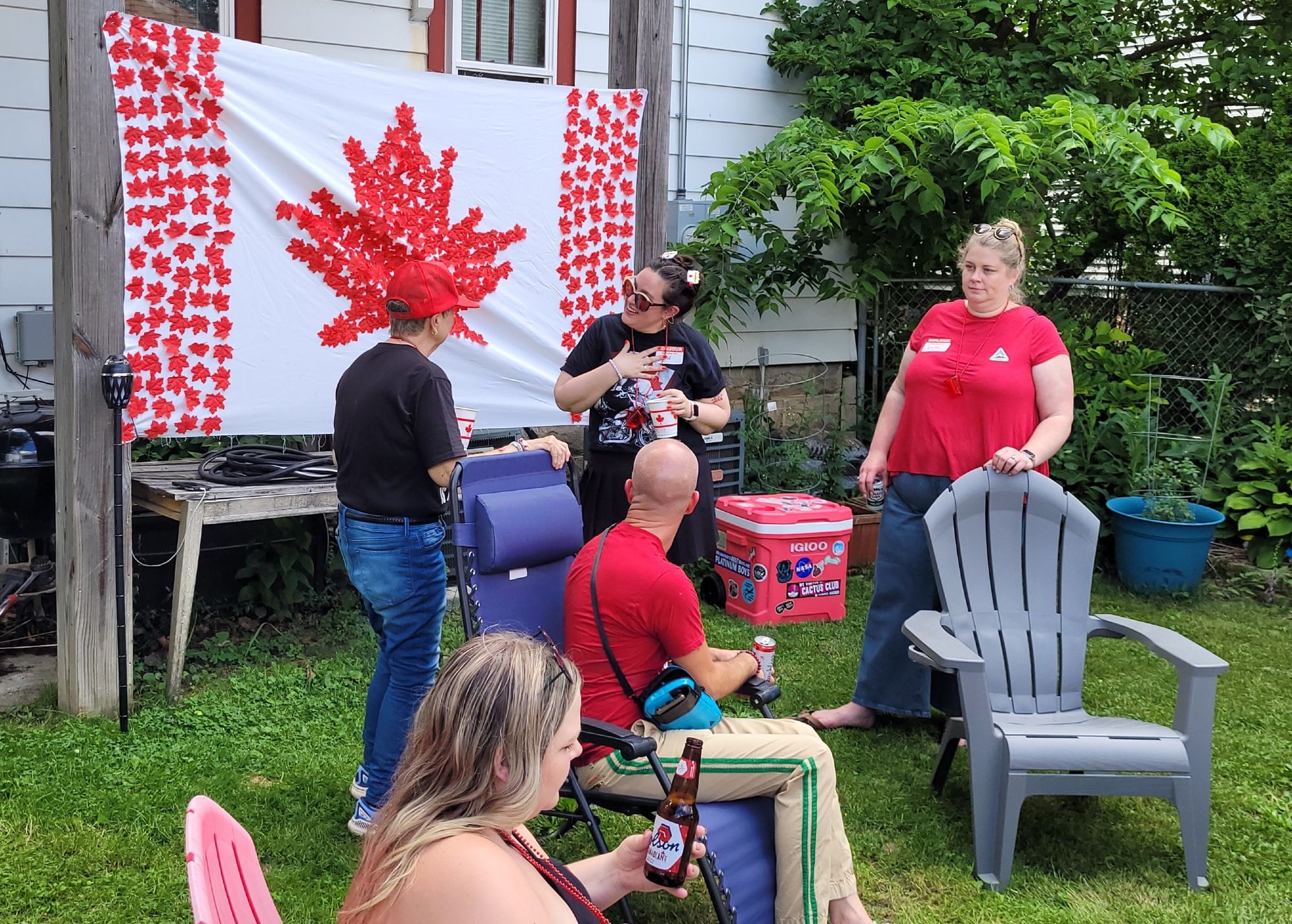 People chilling in the backyard celebrating Canada Day.