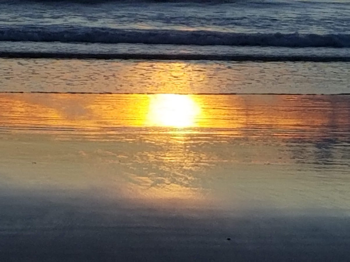 the rising sun's reflection on the beach at the turn of the tide. Taken at Salisbury Beach, Massachusetts, USA