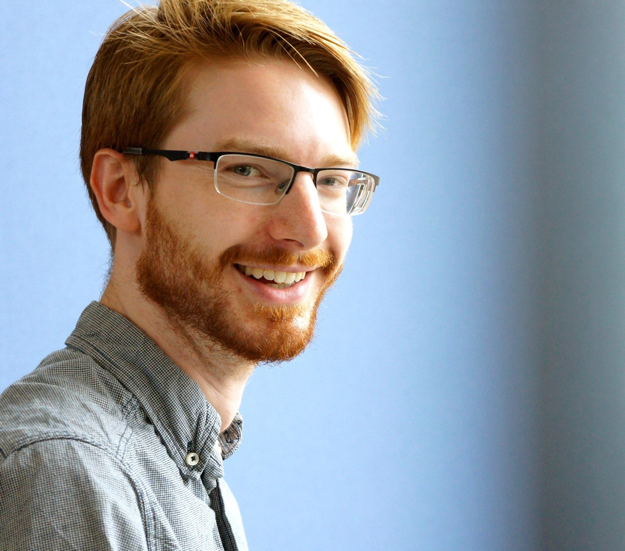 portrait picture of neil tomas smith with blue background